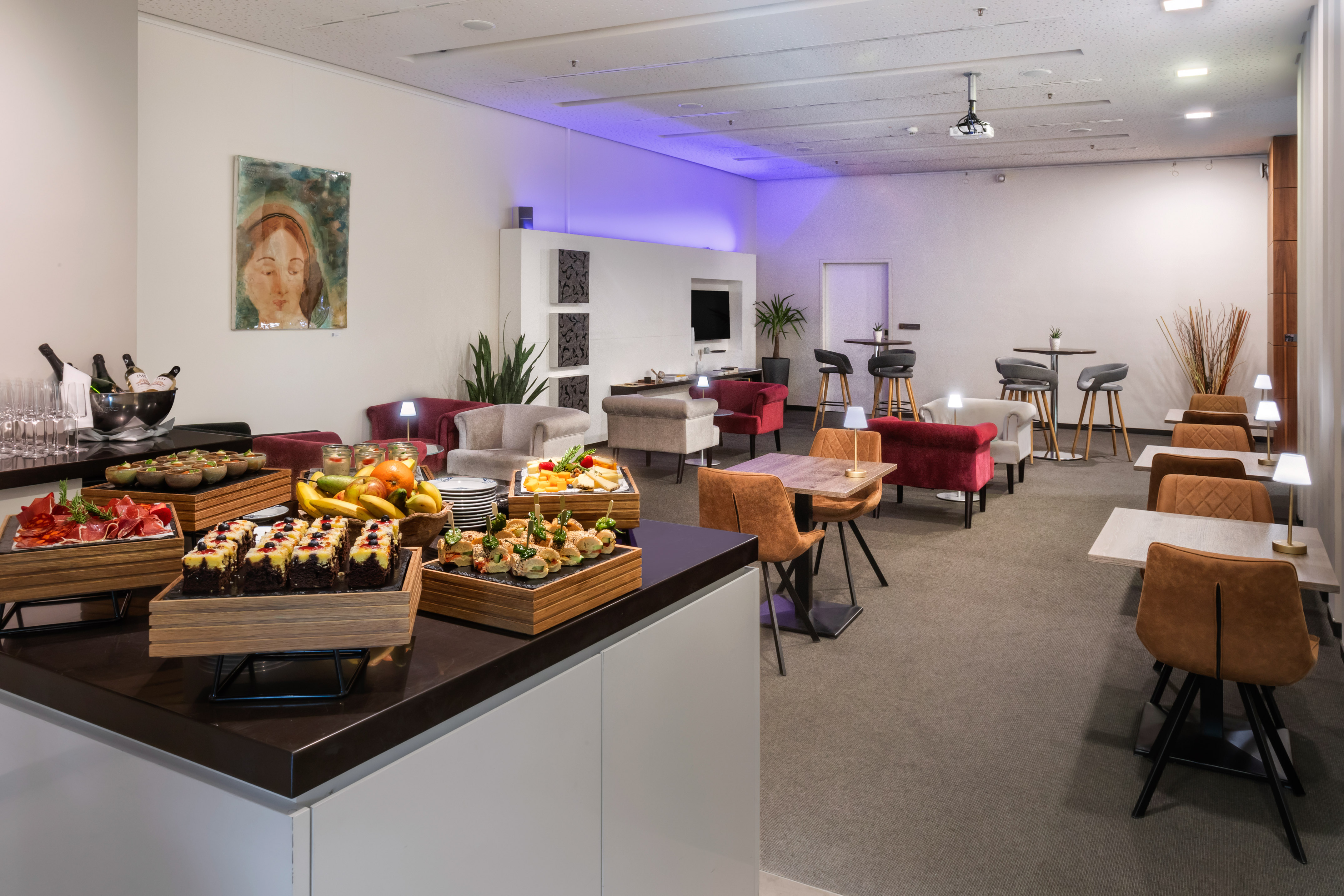 Modern event lounge with catering buffet, diverse seating, and contemporary design.