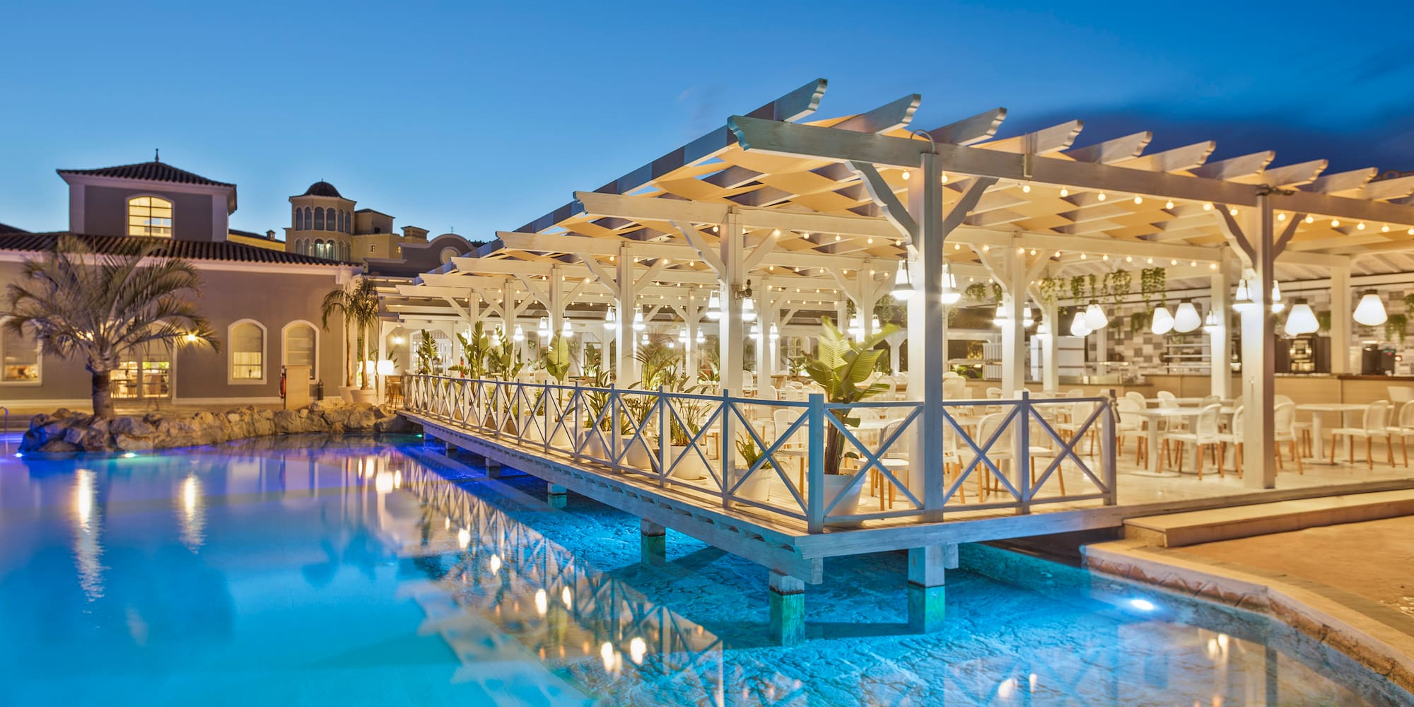 a pool with a covered deck and a building