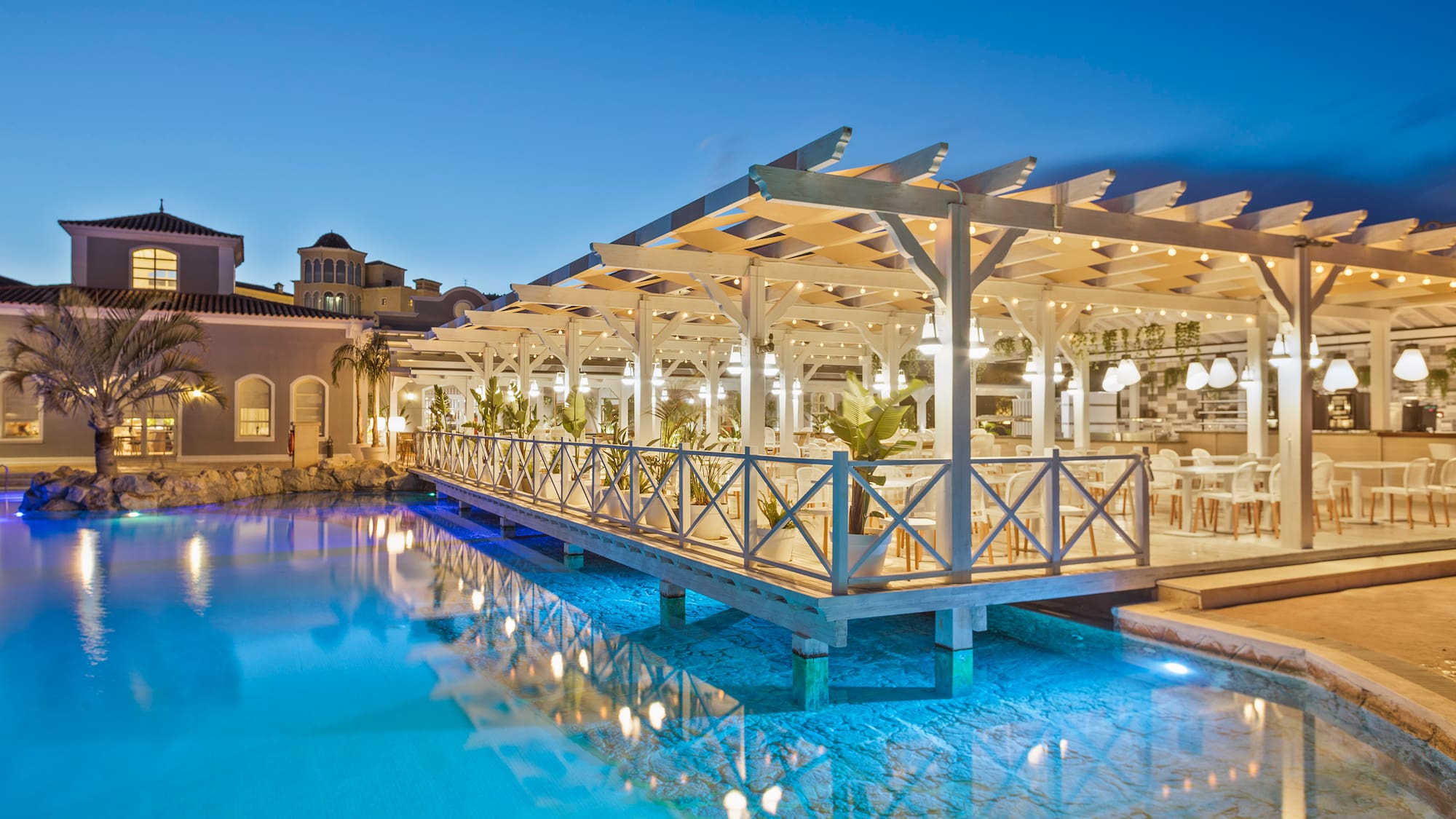 a pool with a covered deck and a building