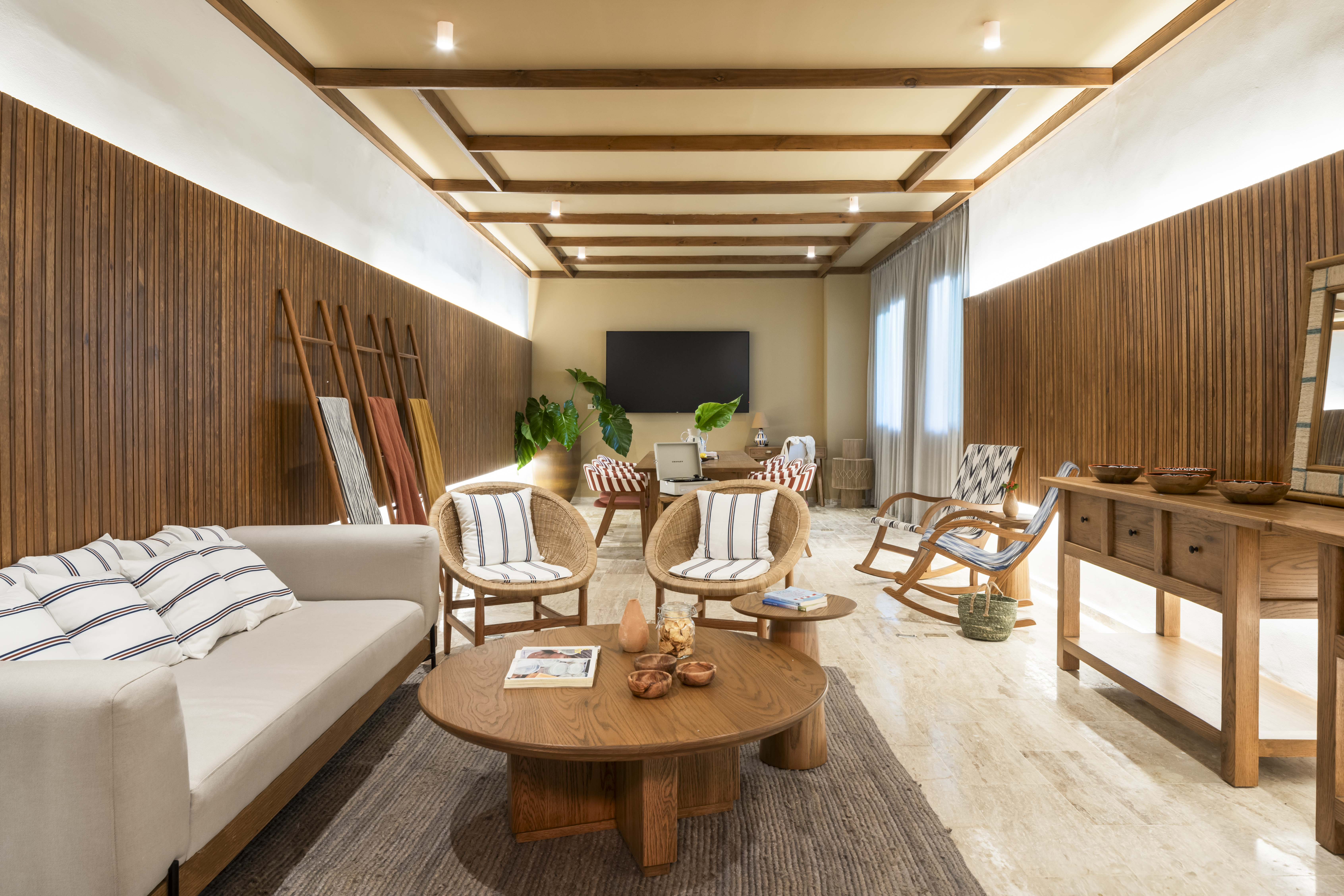 Natural modern living room with wood panels, rattan chairs, and wooden furniture.