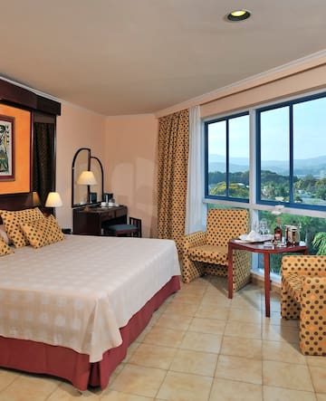 a room with a bed and chairs