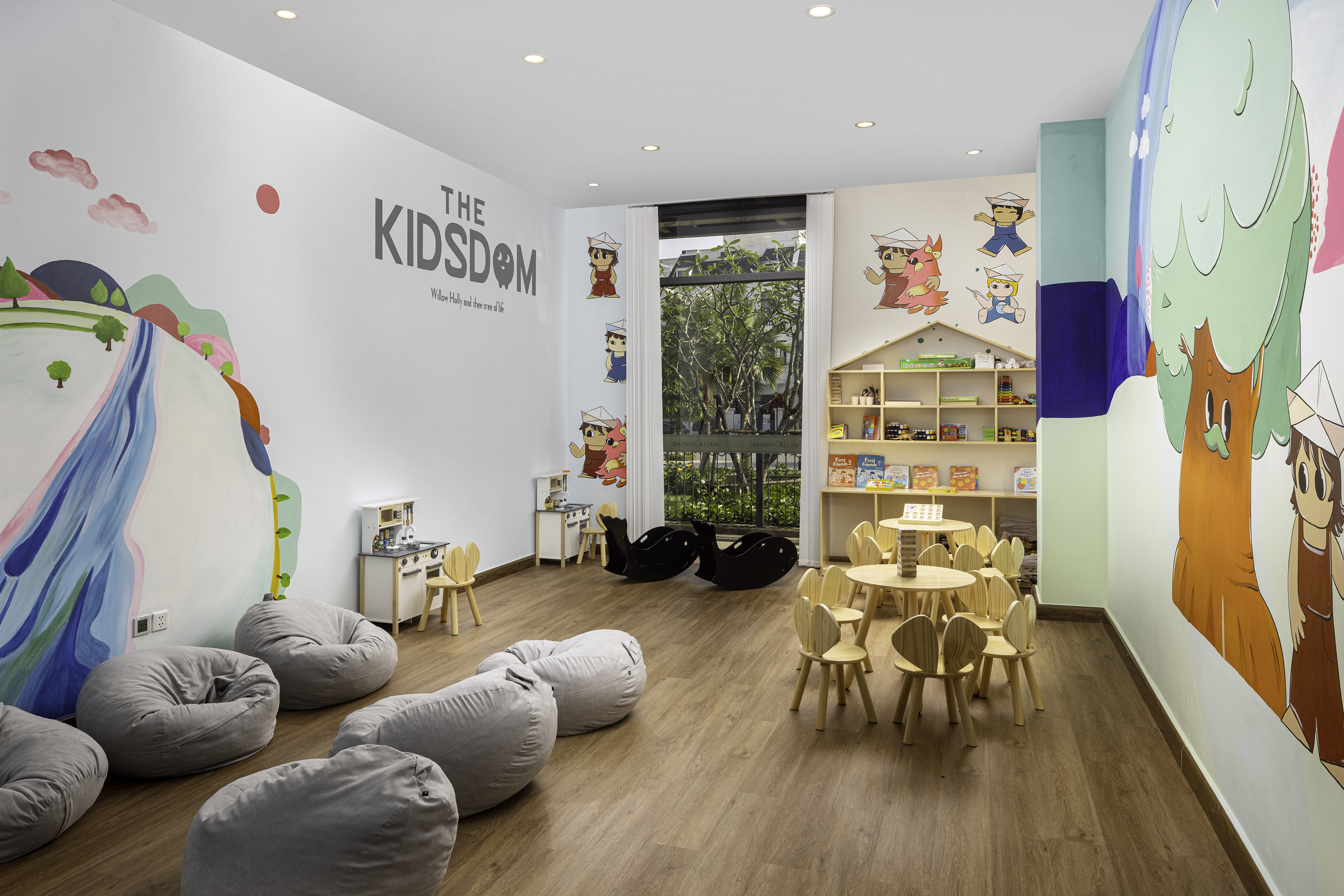 Kids' playroom with colorful murals, bean bags, wooden tables, play kitchen.