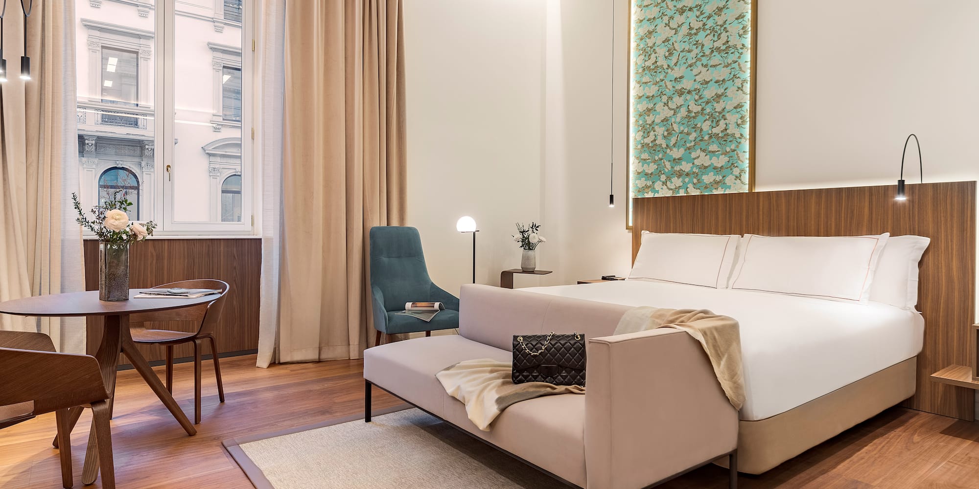 Milan views from a junior suite bedroom with a bed and chair at the Luxury hotel Palazzo Cordusio