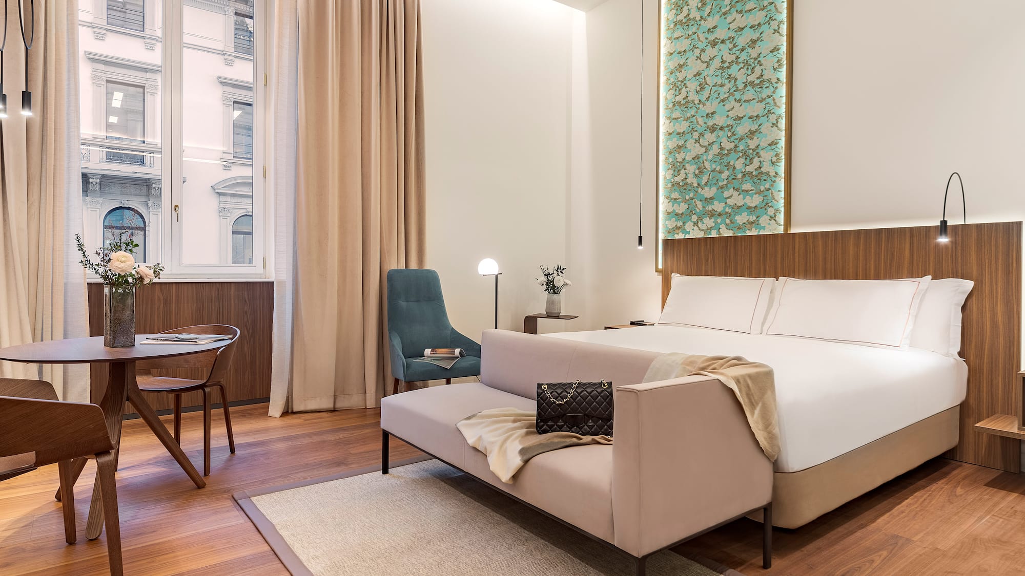 Milan views from a junior suite bedroom with a bed and chair at the Luxury hotel Palazzo Cordusio