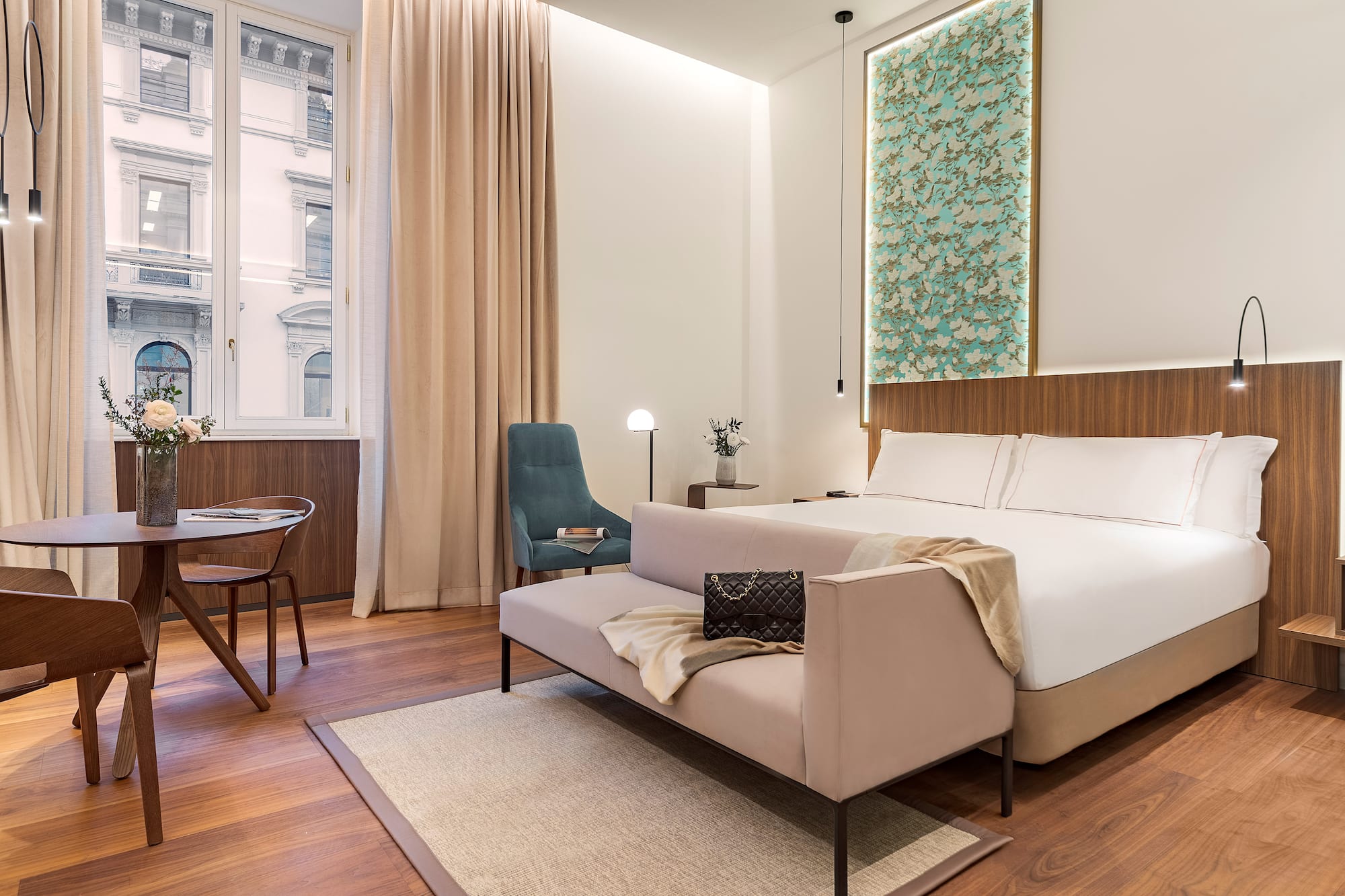 Milan views from a junior suite bedroom with a bed and chair at the Luxury hotel Palazzo Cordusio