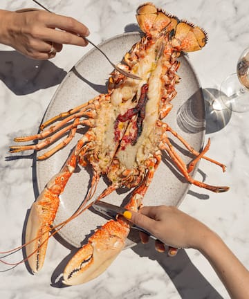 a lobster on a plate with a fork and knife