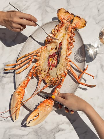 a lobster on a plate with a fork and knife
