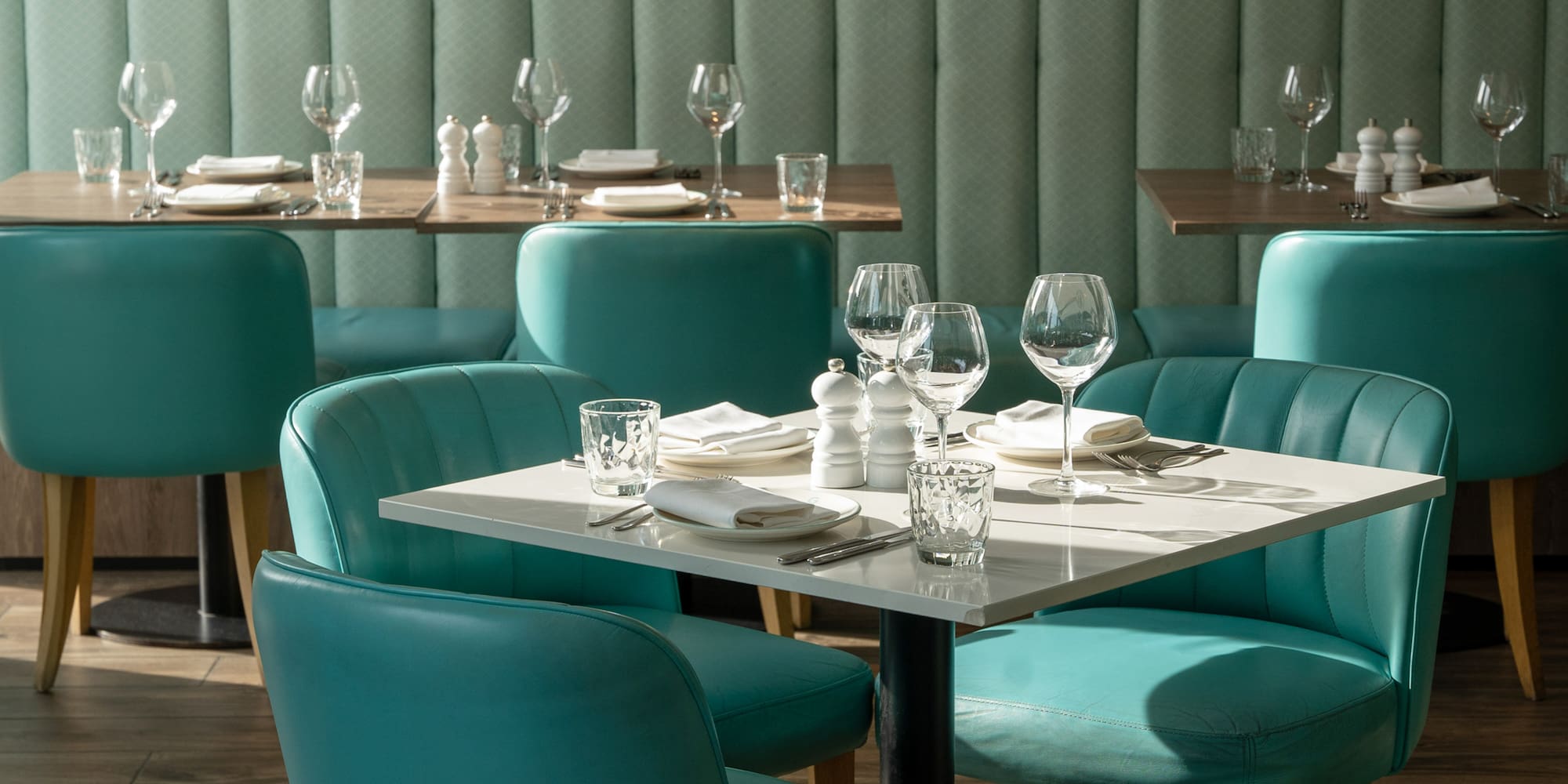 a table with empty glasses and a white tablecloth in a restaurant