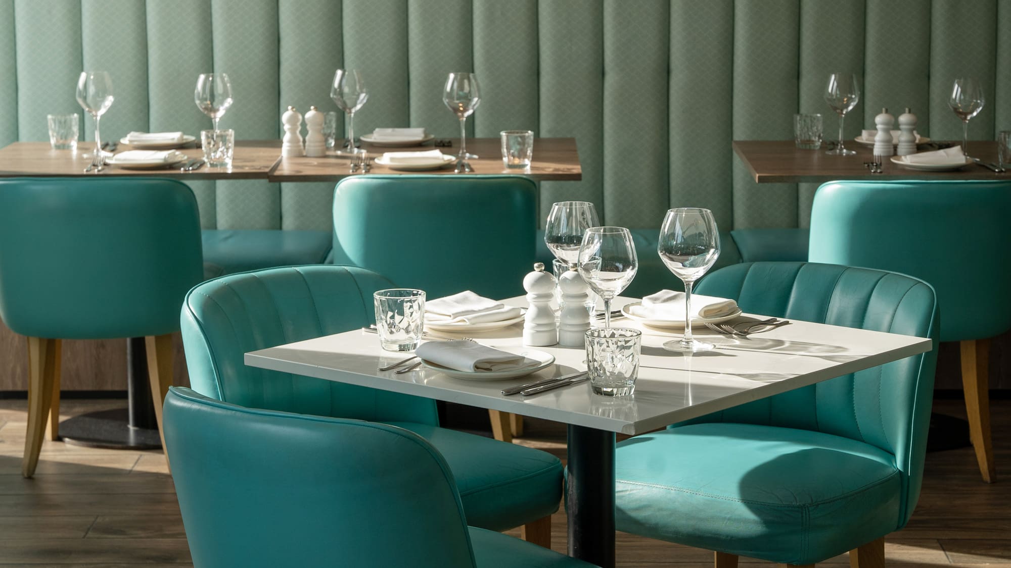a table with empty glasses and a white tablecloth in a restaurant