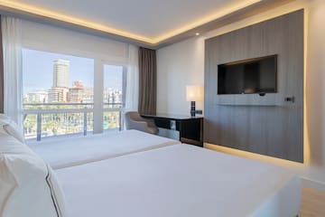 a room with a television and a couple of beds