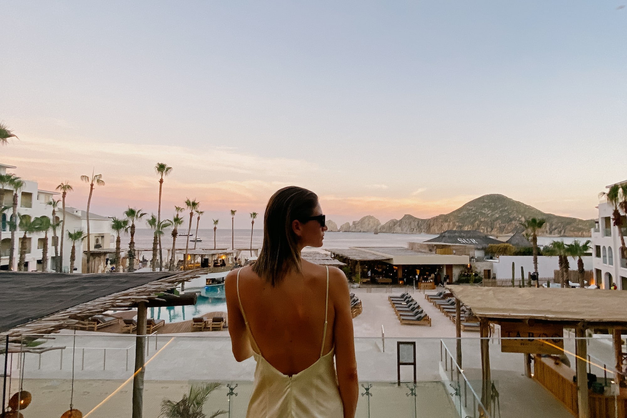 a woman in a dress looking at a beach