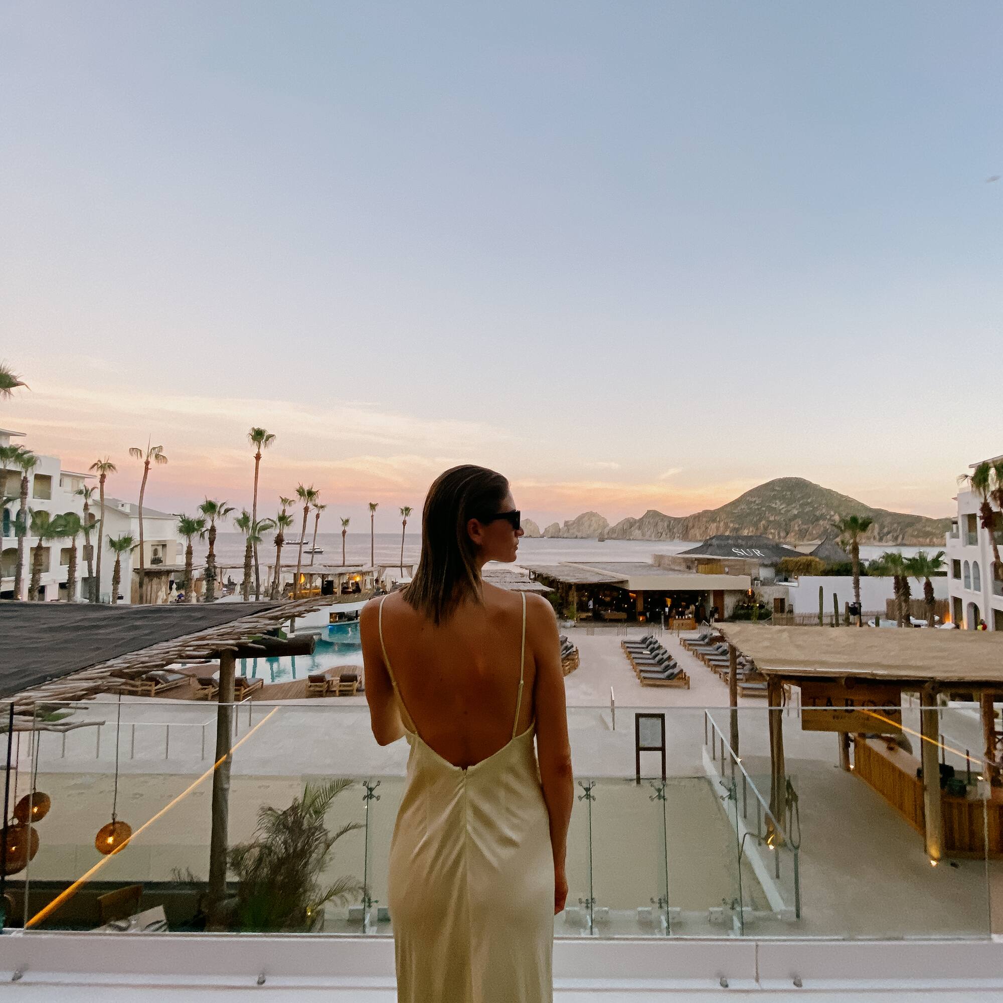 a woman in a dress looking at a beach