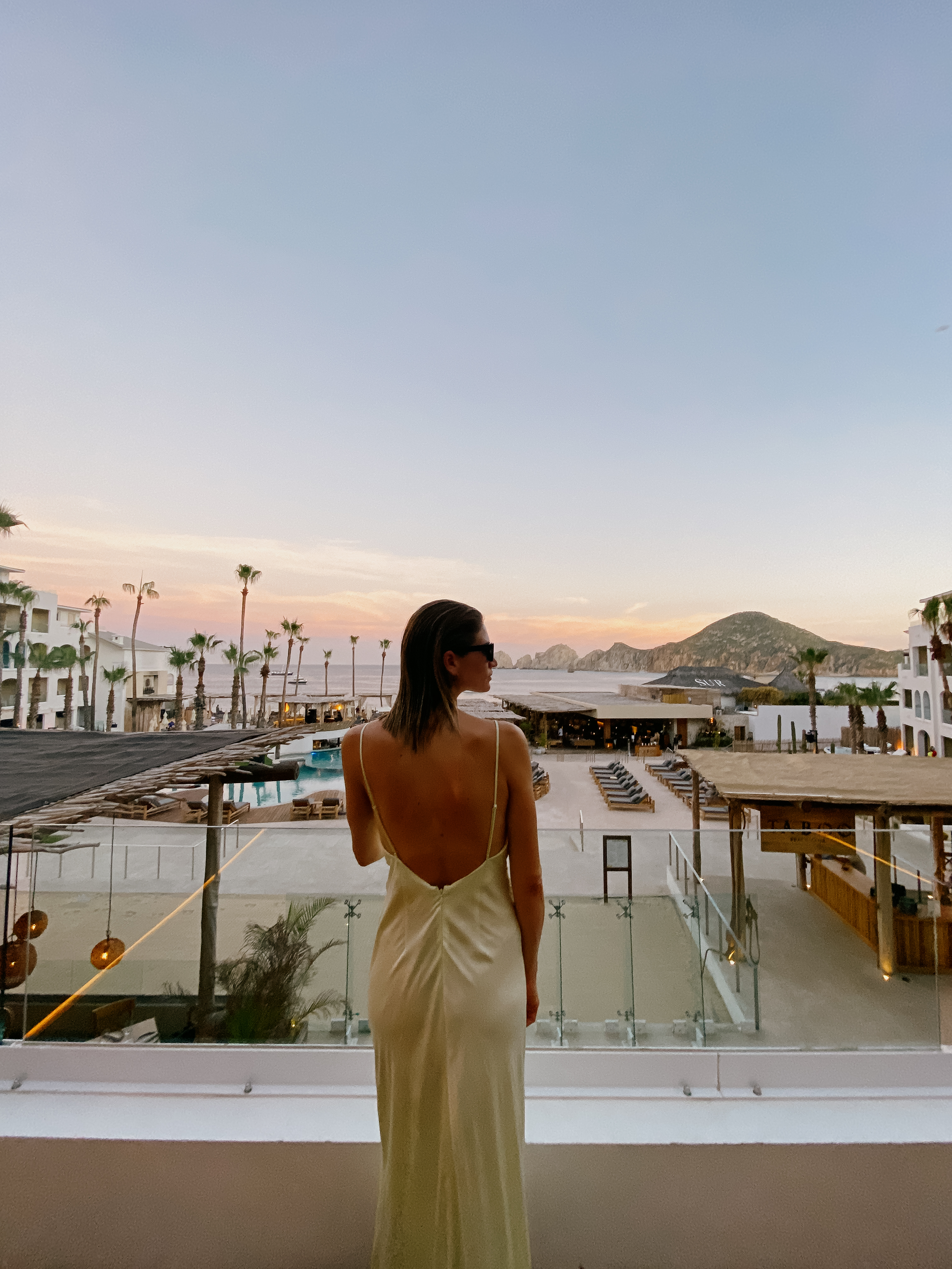a woman in a dress looking at a beach