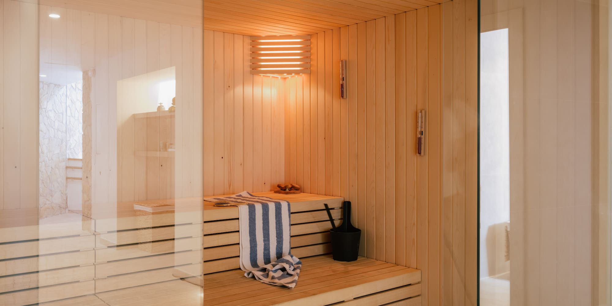 a wooden sauna with a towel and bucket