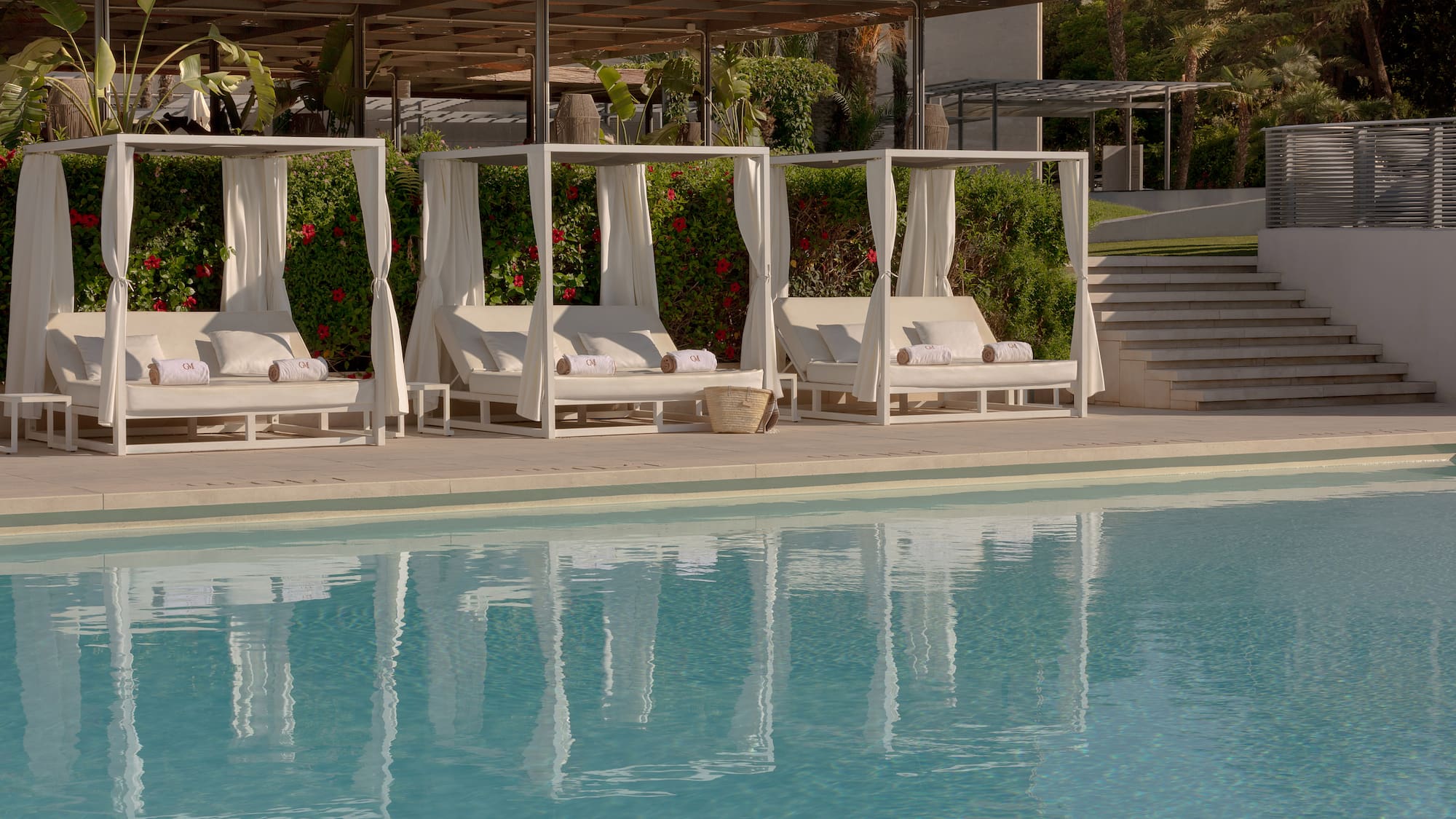 a pool with white beds and white curtains