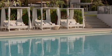 a pool with white beds and white curtains