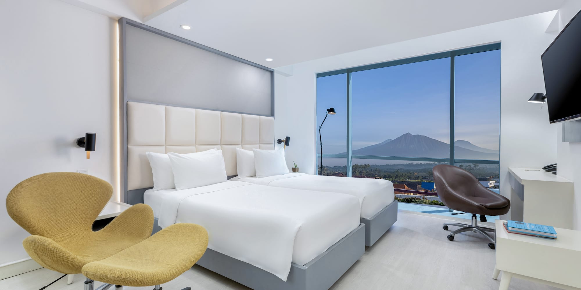 a room with two beds and a large window