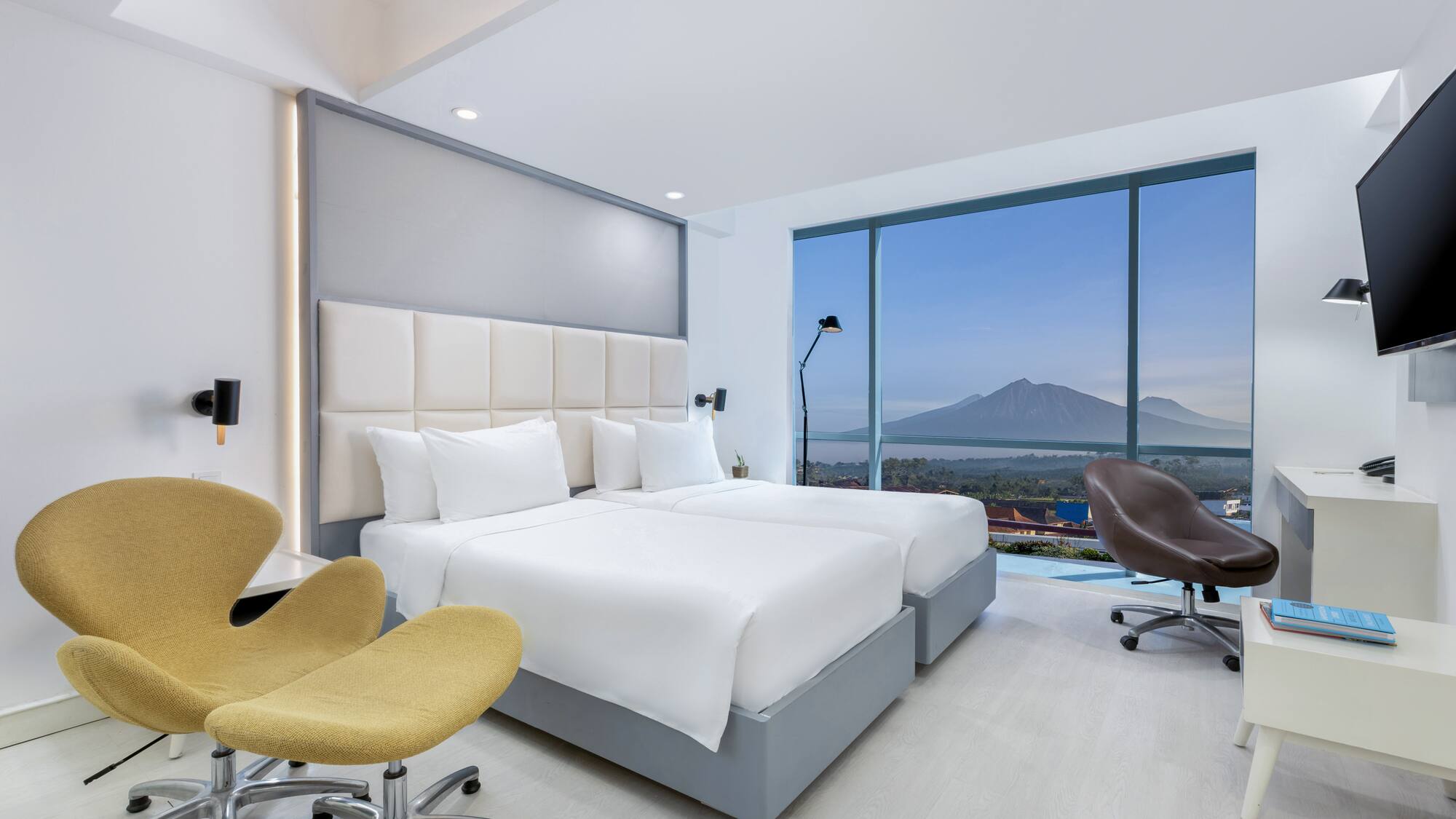 a room with two beds and a large window