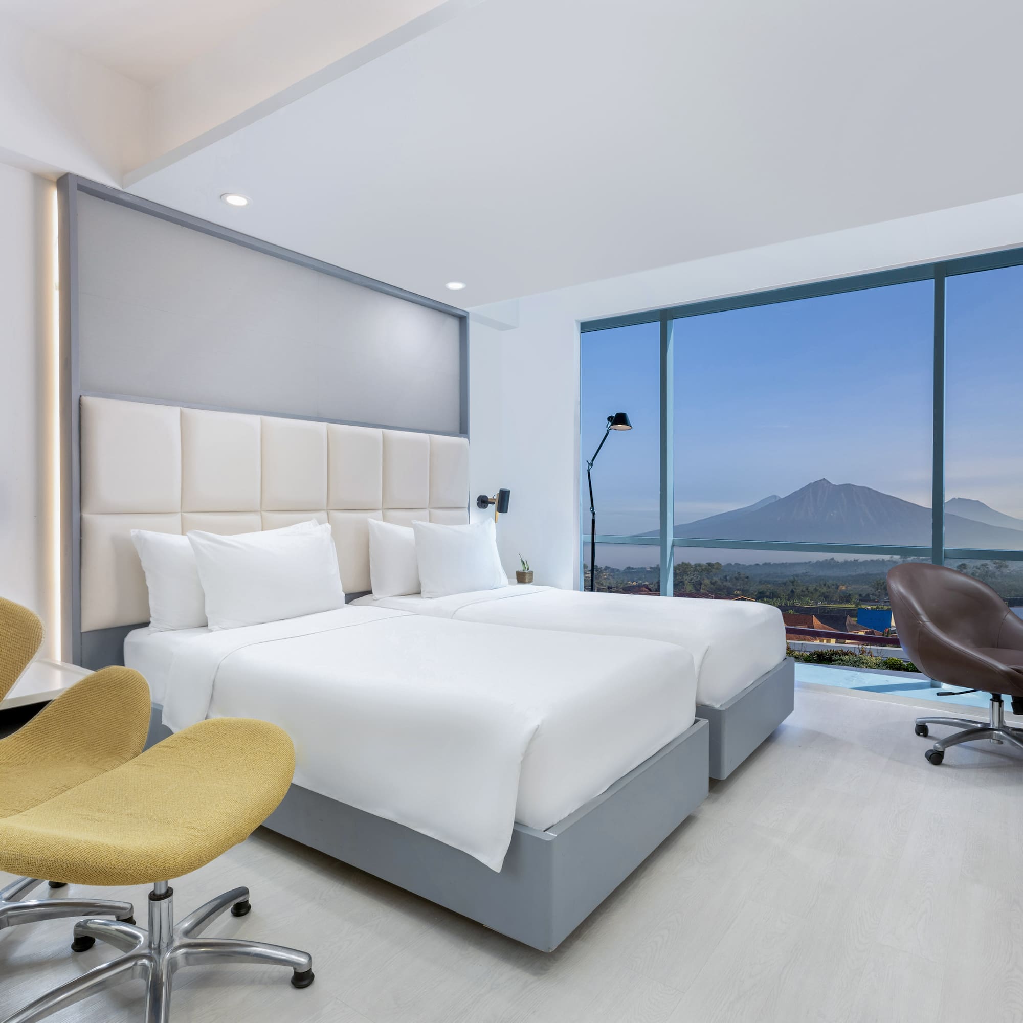 a room with two beds and a large window