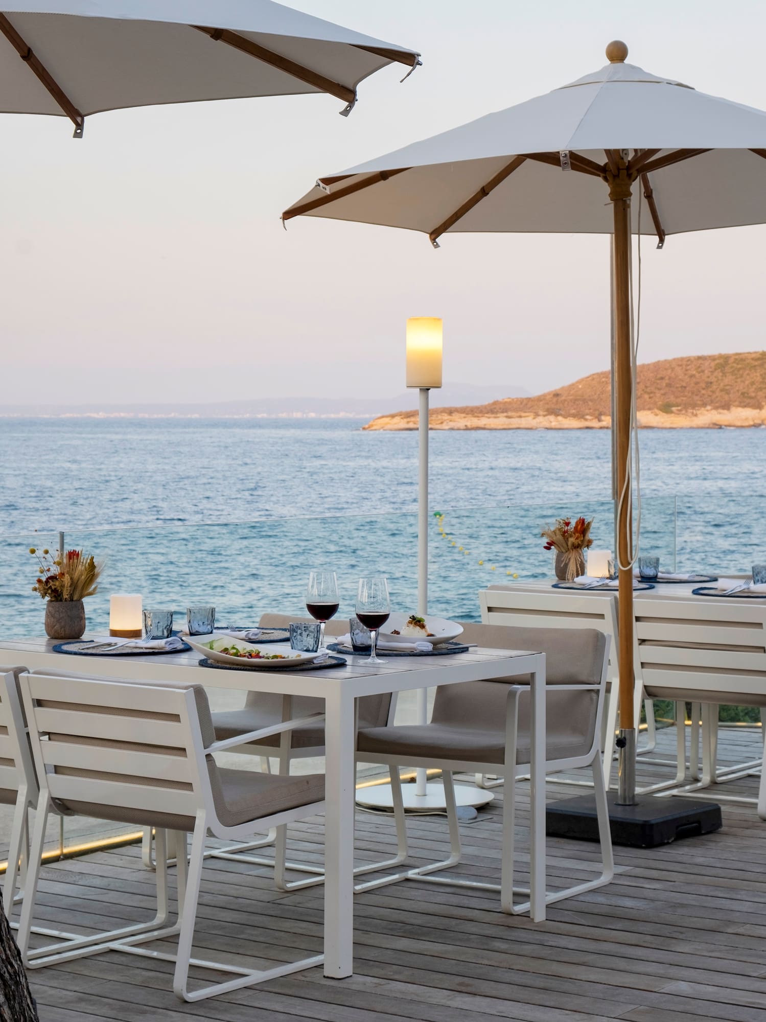 a table and chairs on a deck overlooking a body of water