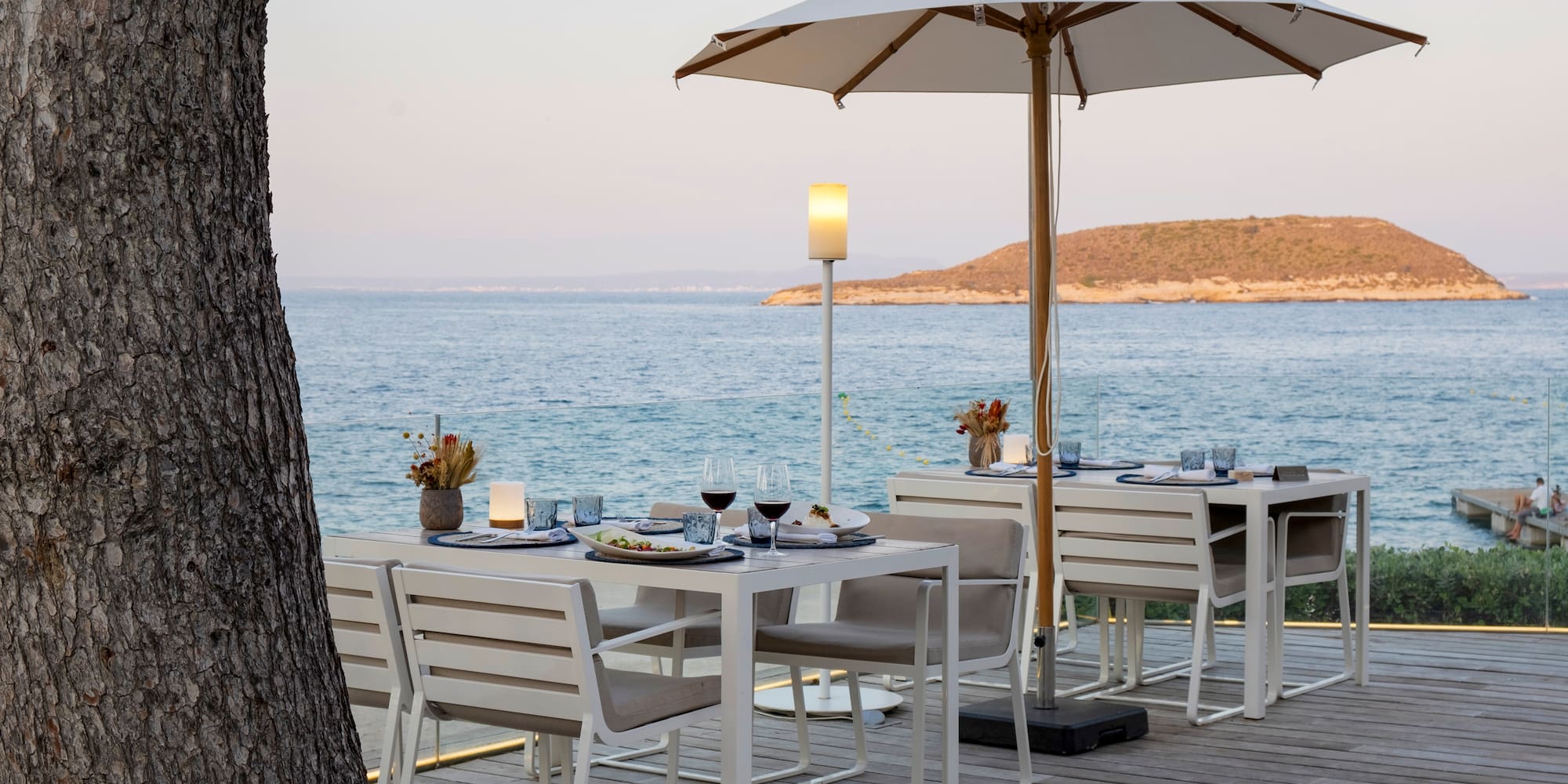 a table and chairs on a deck overlooking a body of water