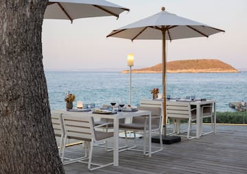 a table and chairs on a deck overlooking a body of water