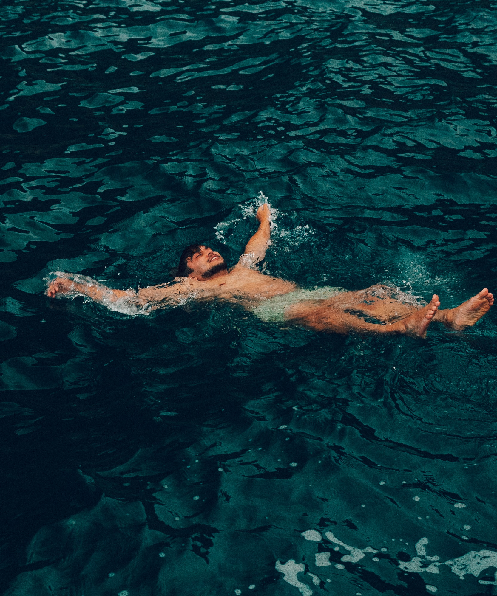 Nadador flotando en aguas profundas y tranquilas.