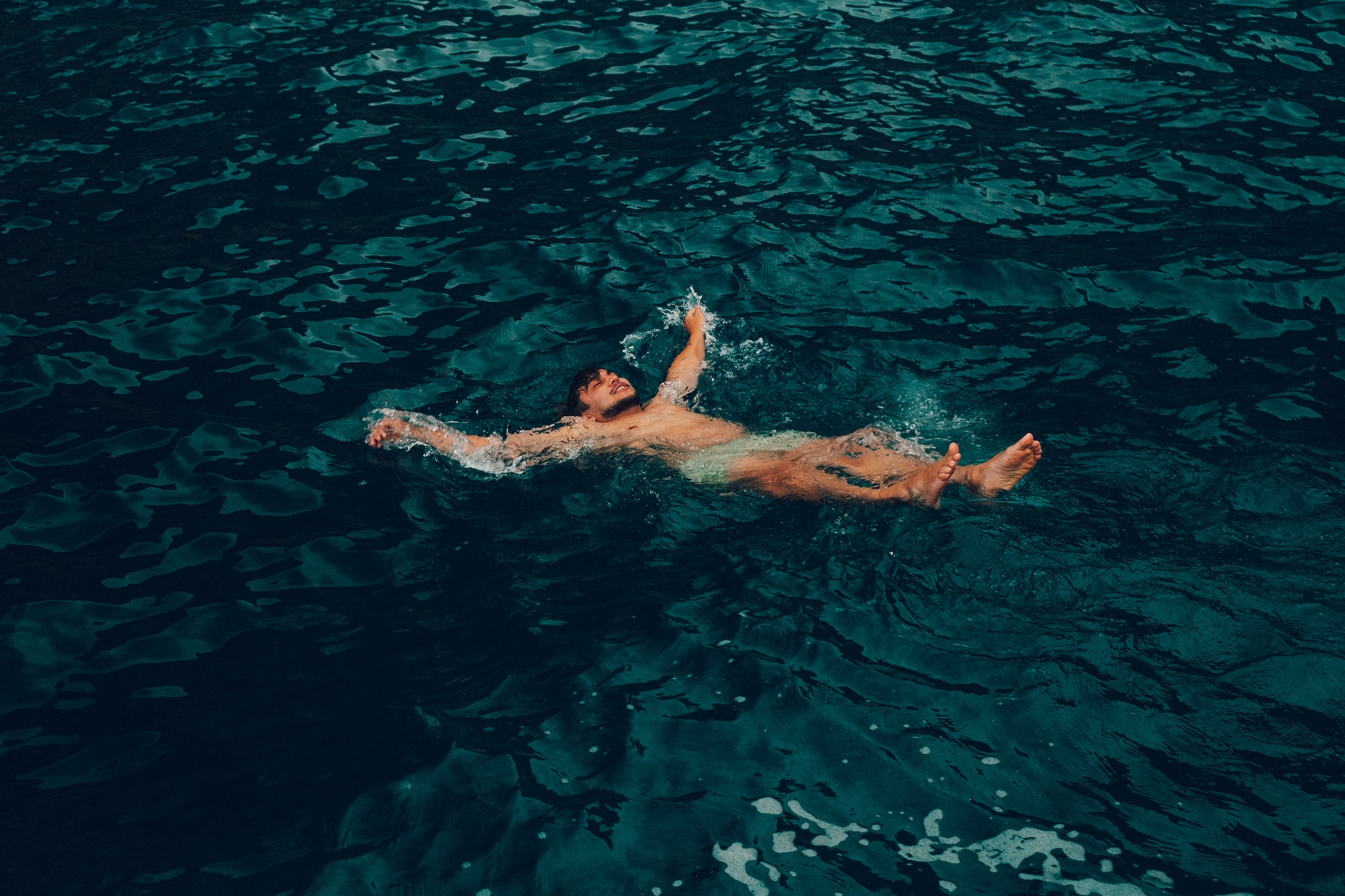 Nadador flotando en aguas profundas y tranquilas.