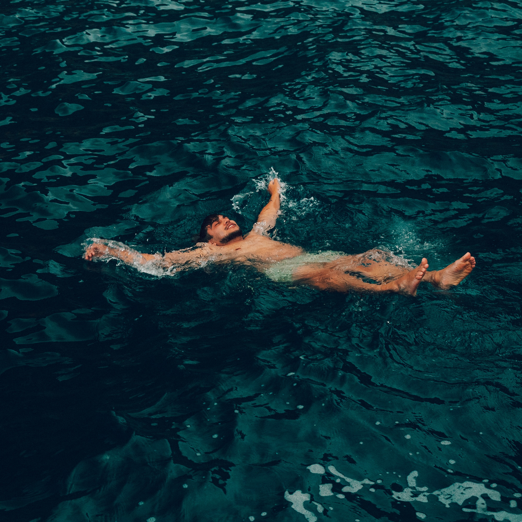 Nadador flotando en aguas profundas y tranquilas.