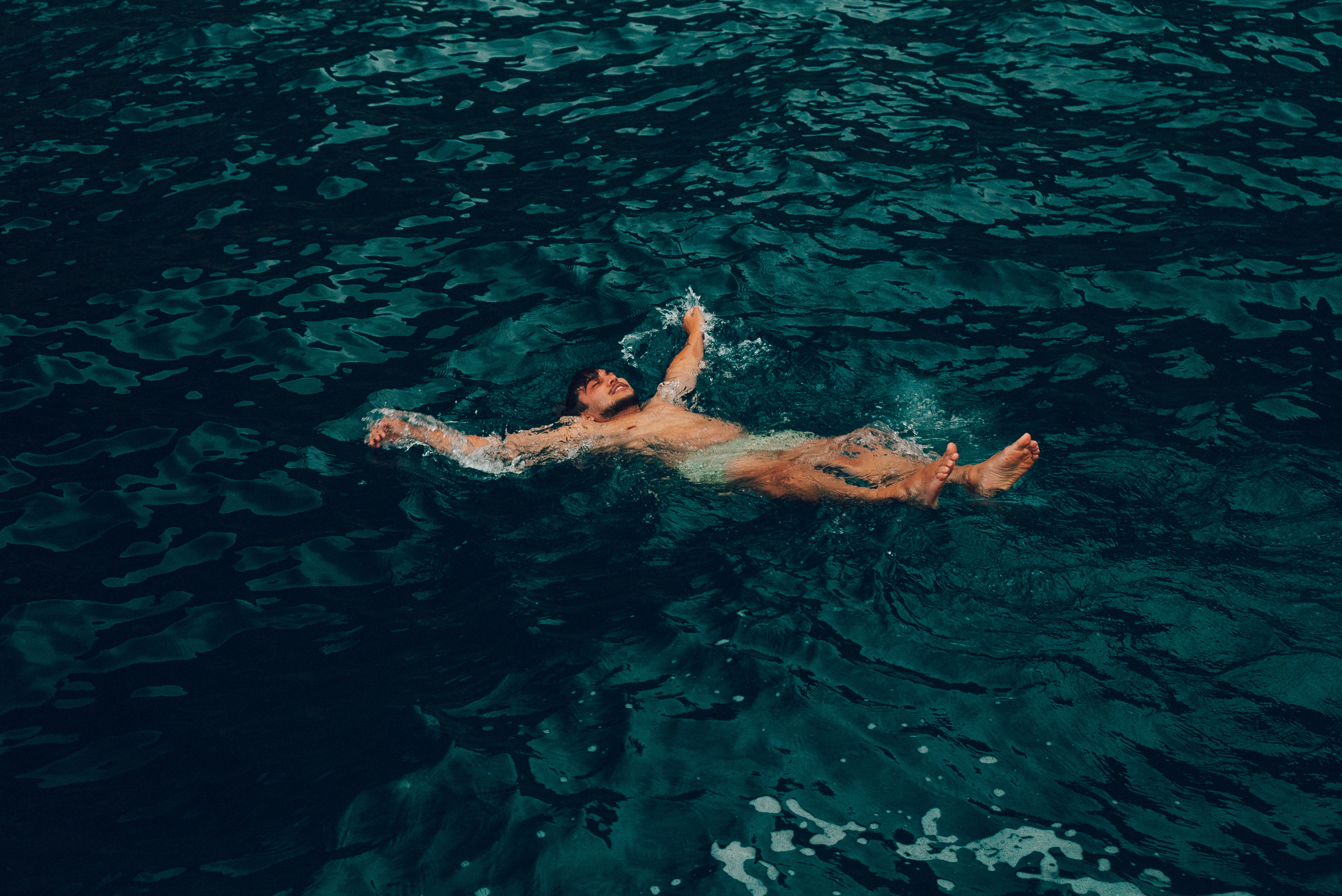 Nadador flotando en aguas profundas y tranquilas.