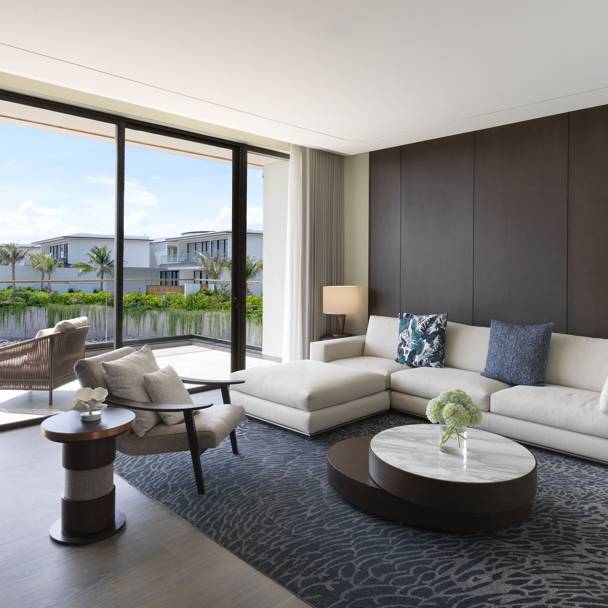 a living room with a large glass wall and a large couch