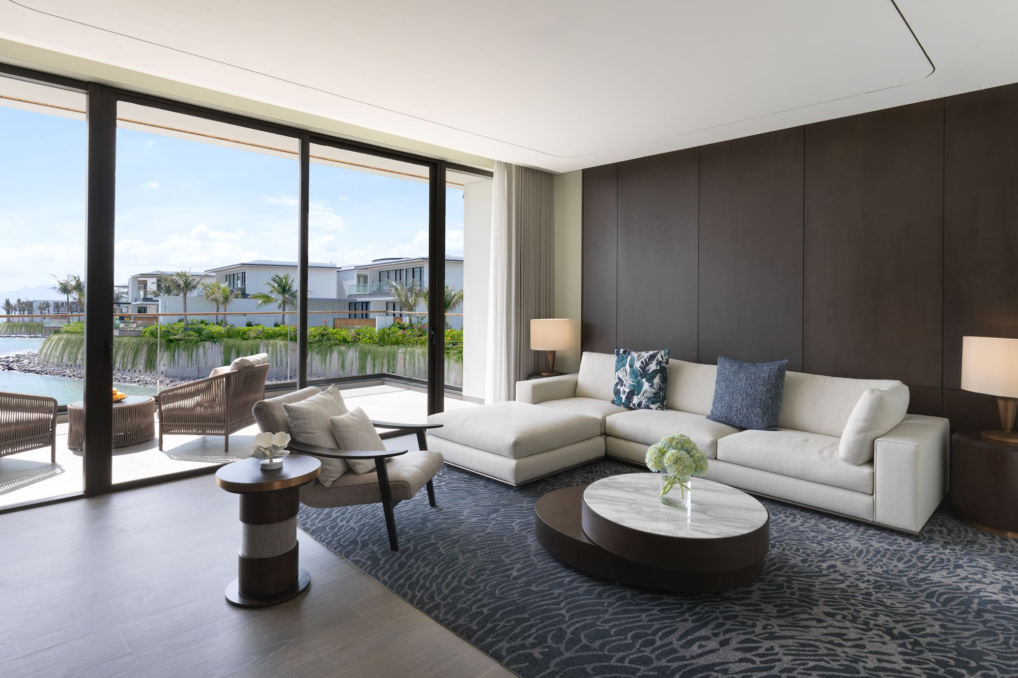 a living room with a large glass wall and a large couch