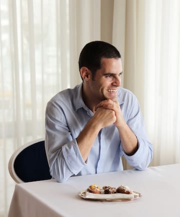 a man sitting at a table with food on it
