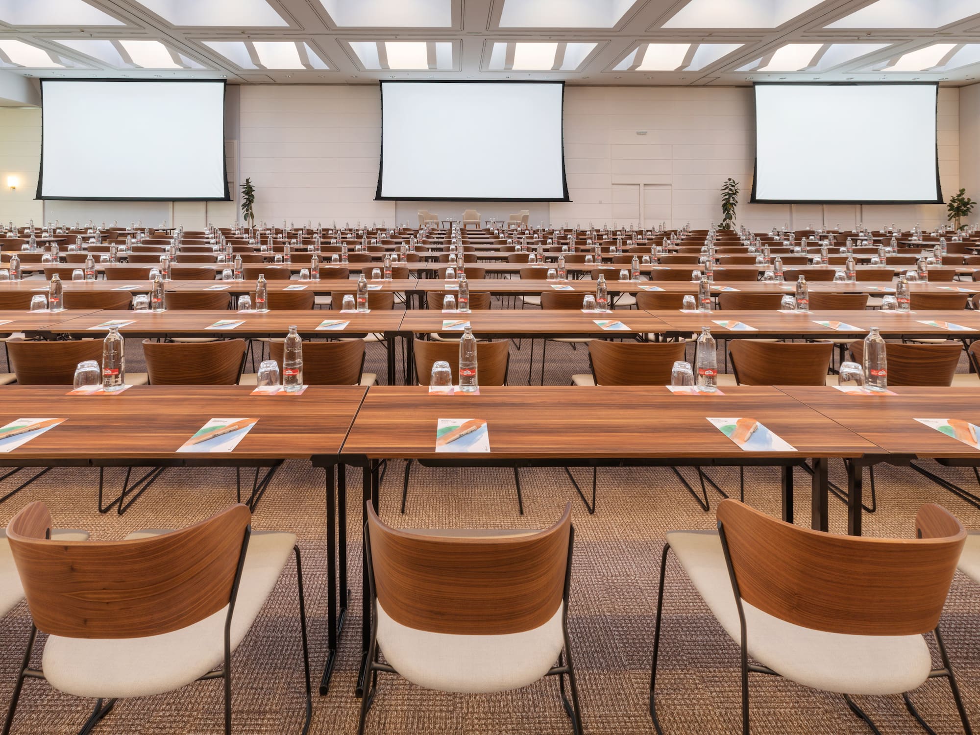 a room with tables and chairs and a projector screen