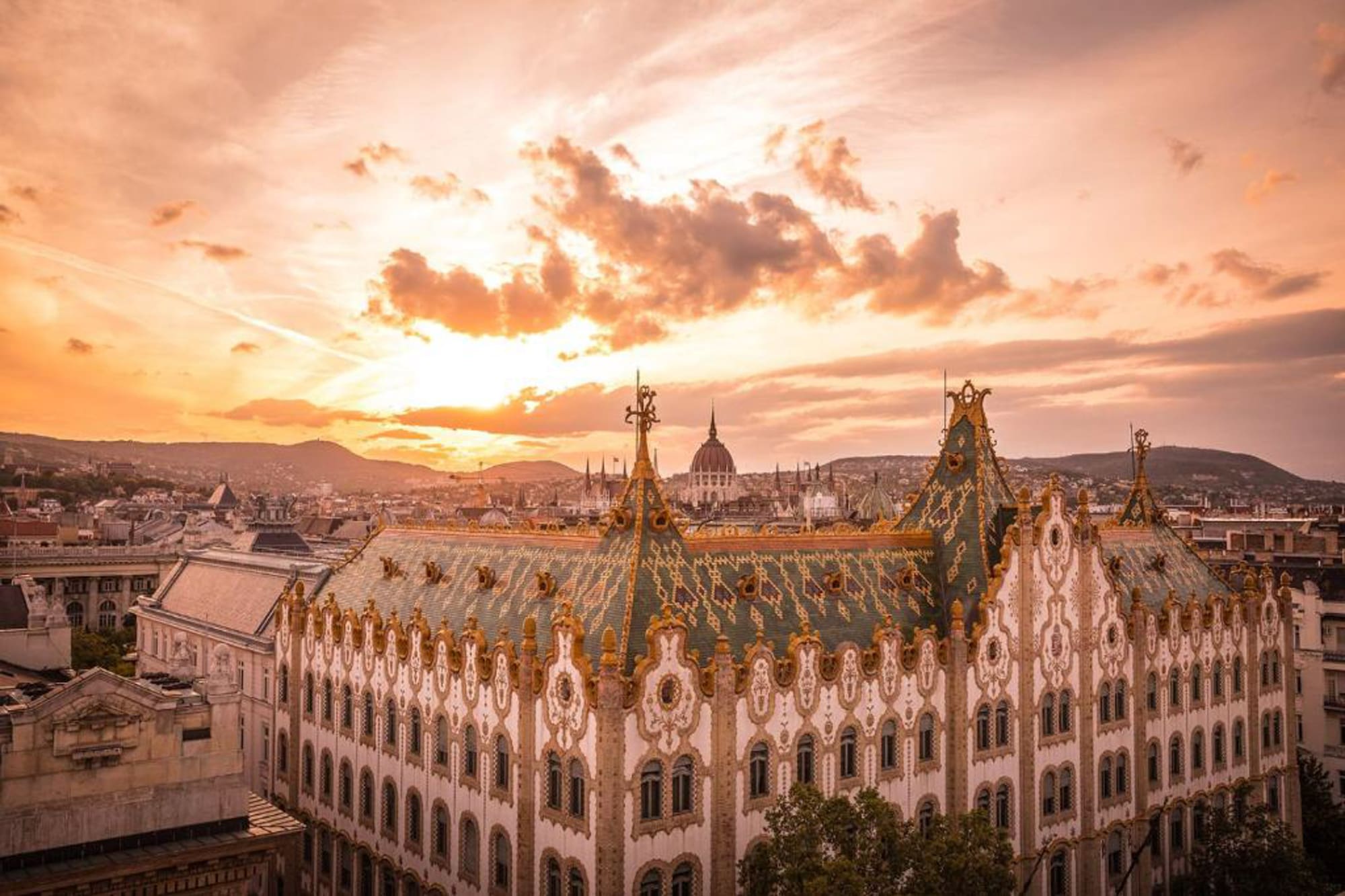 a large building with gold trim and a city in the background