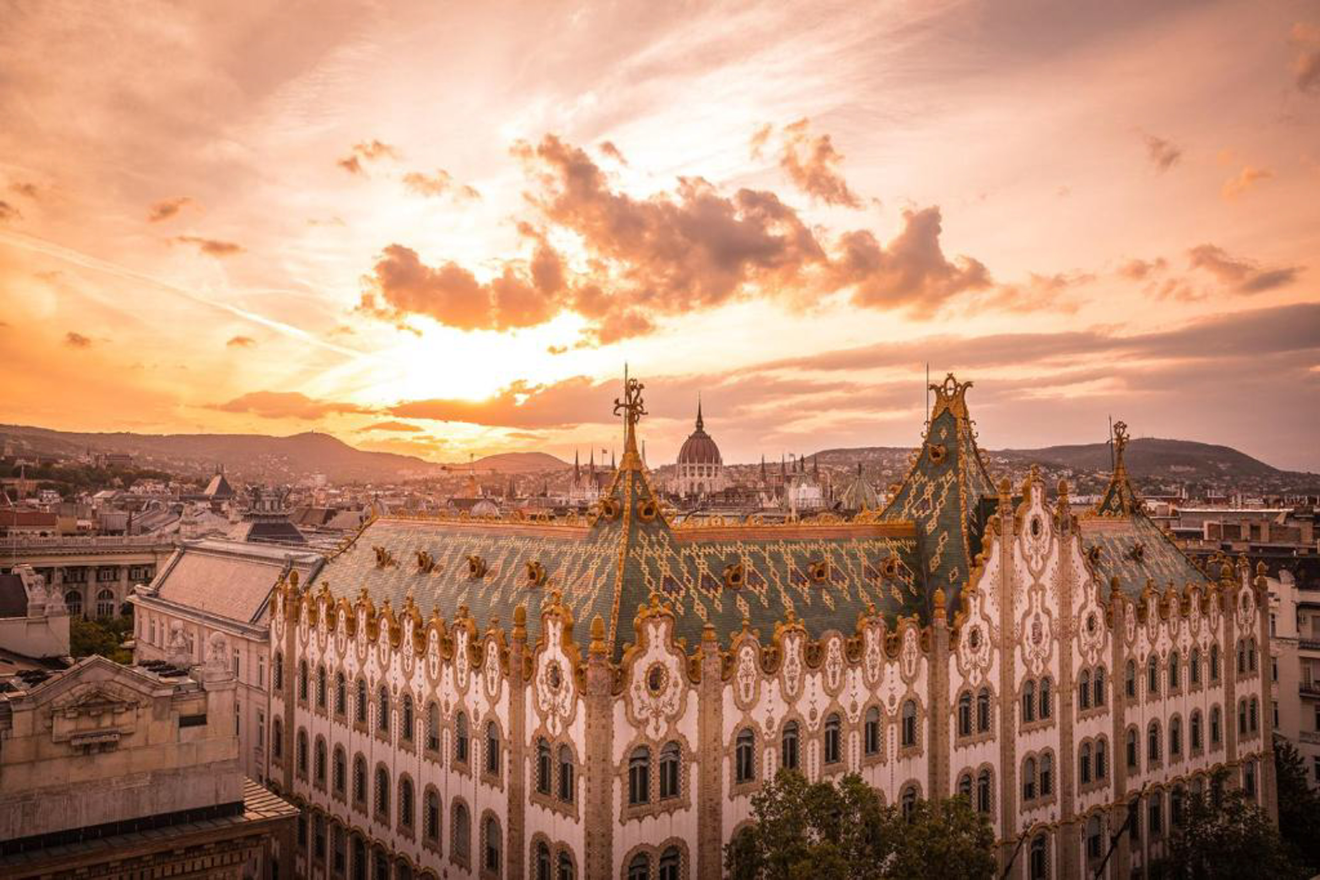 a large building with gold trim and a city in the background
