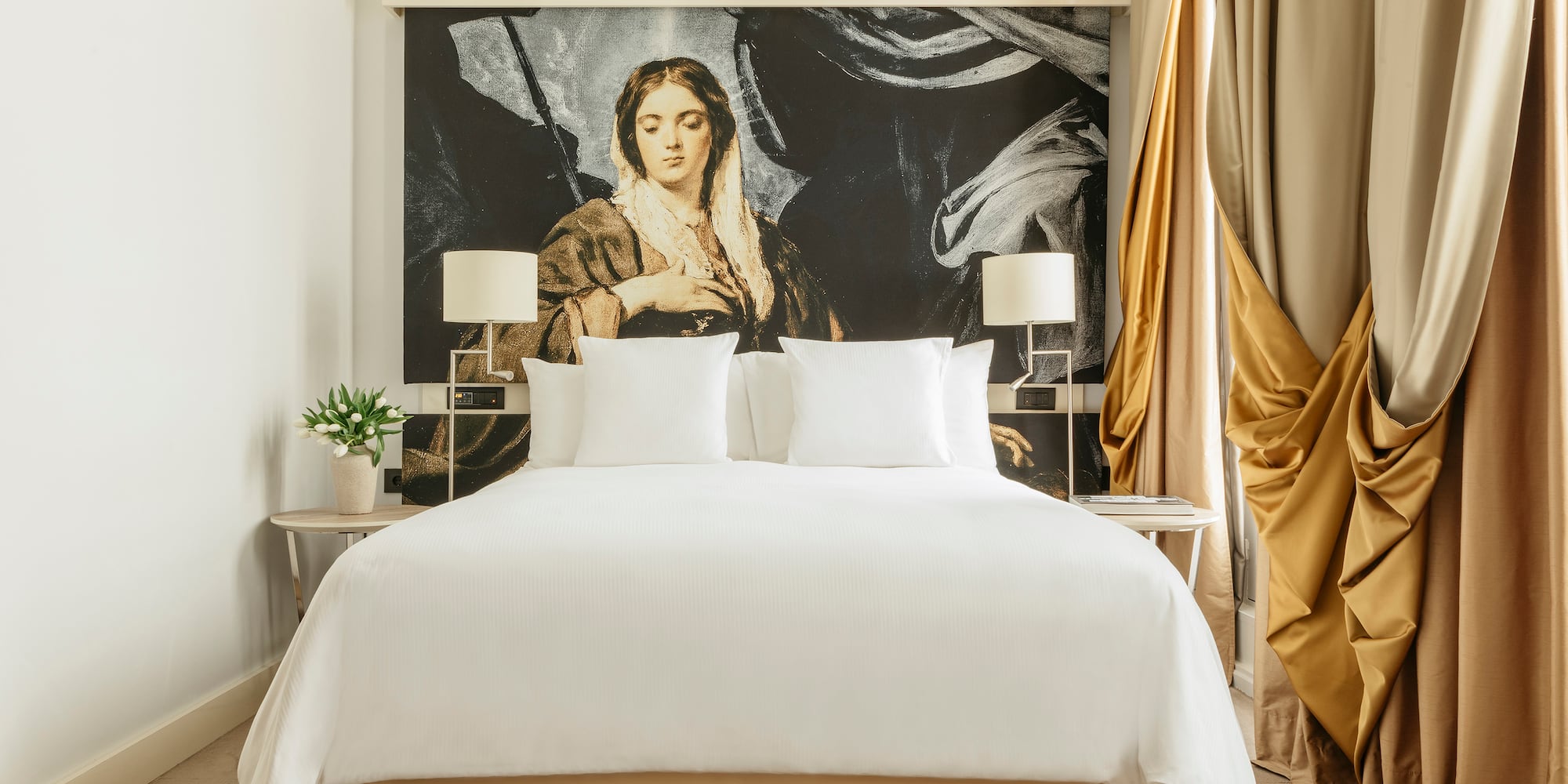 a bed with a large painting on the wall