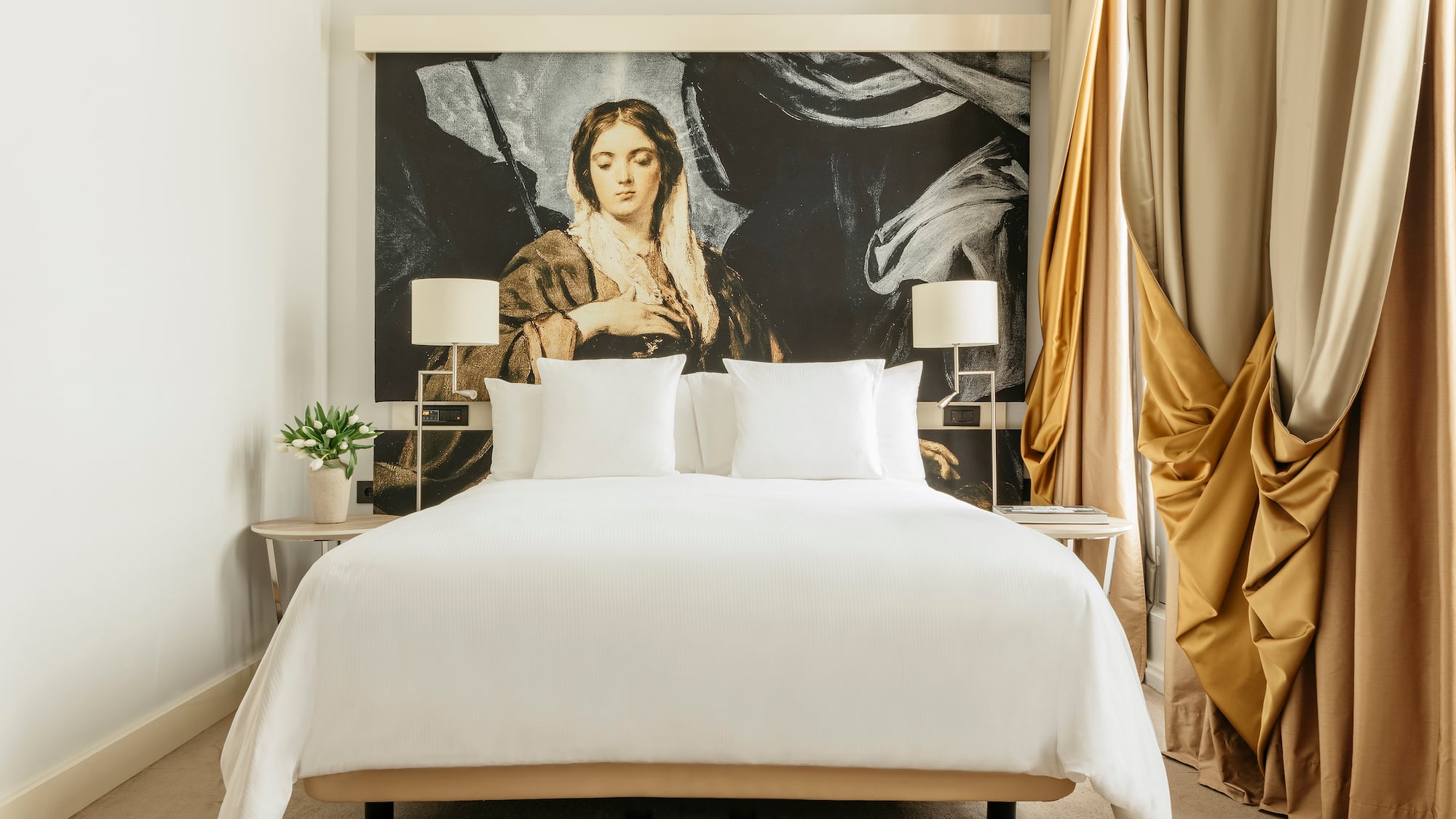 a bed with a large painting on the wall
