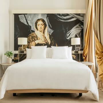 a bed with a large painting on the wall