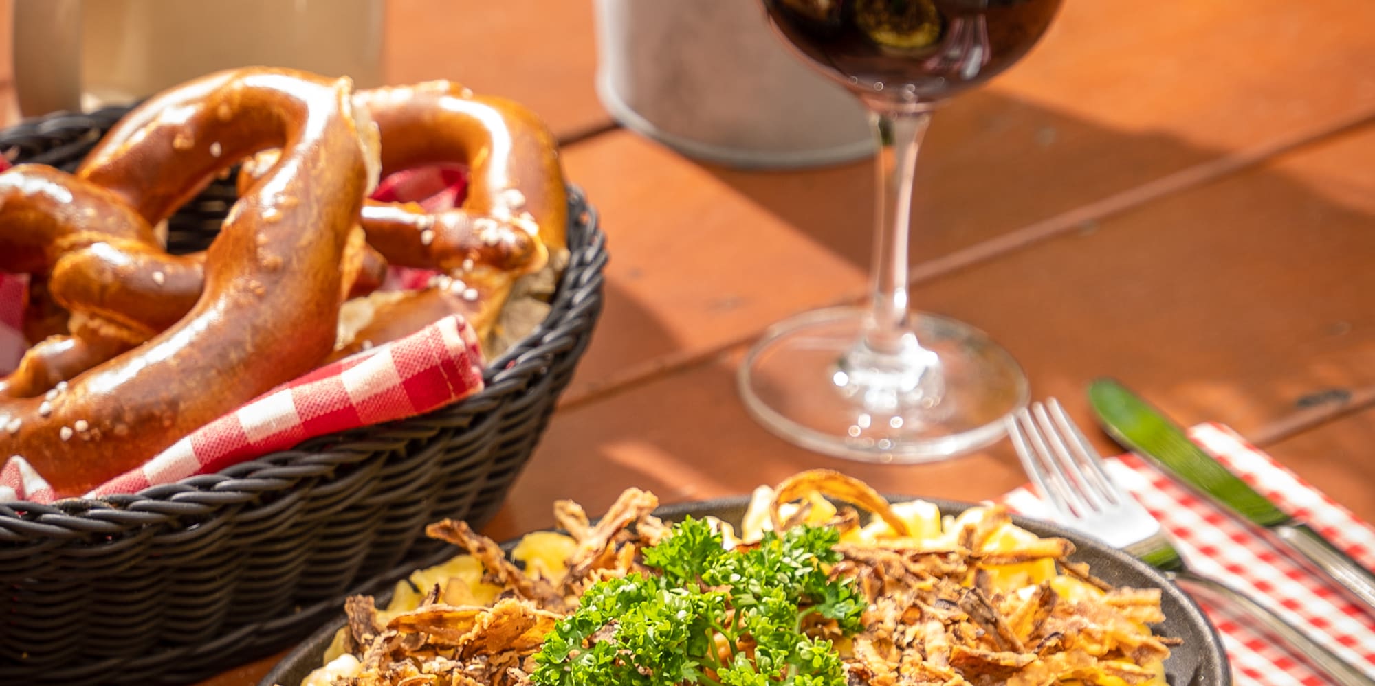 food on a plate next to a glass of wine