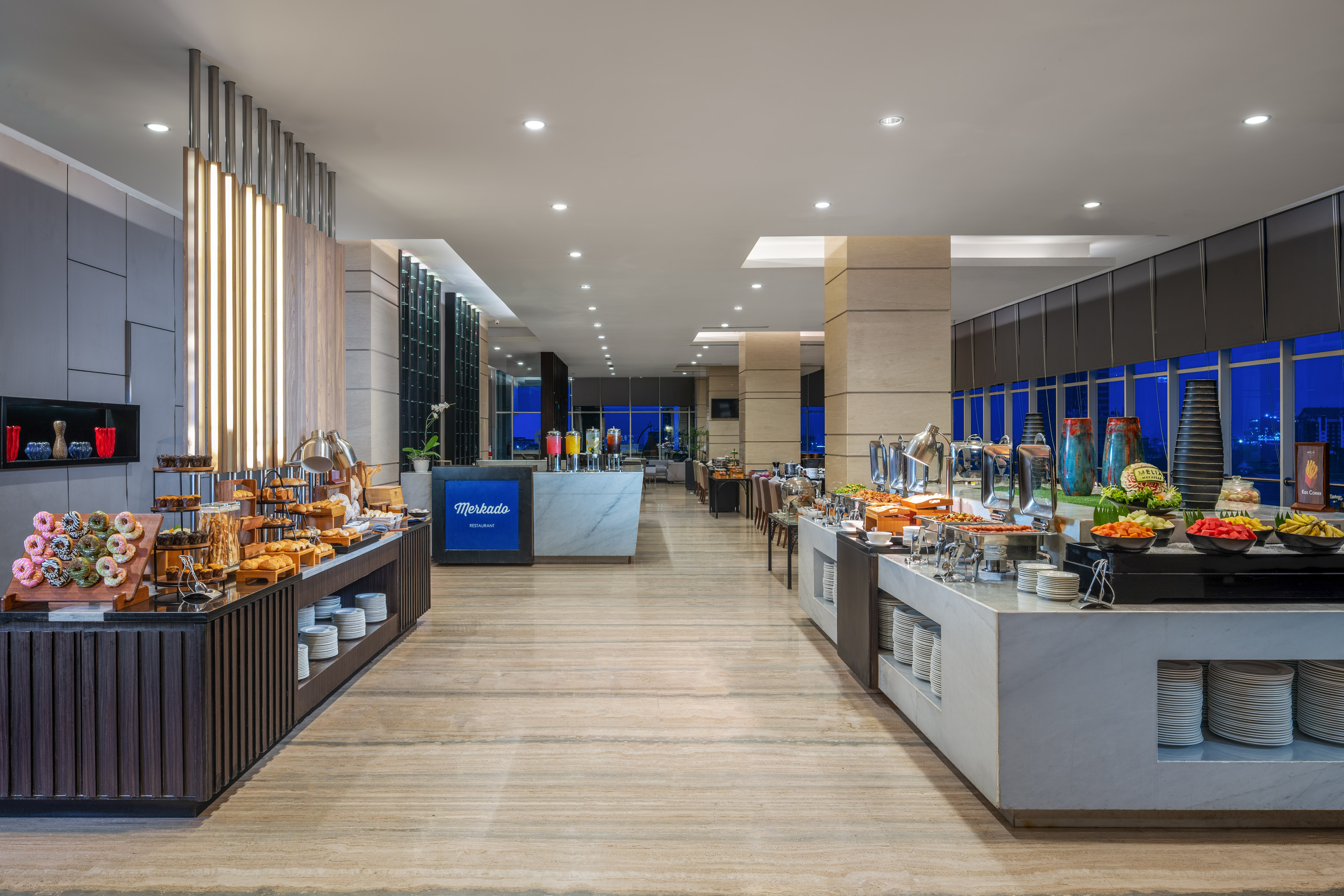 Modern Mercado Restaurant buffet with pastries, hot food, and fresh fruit.