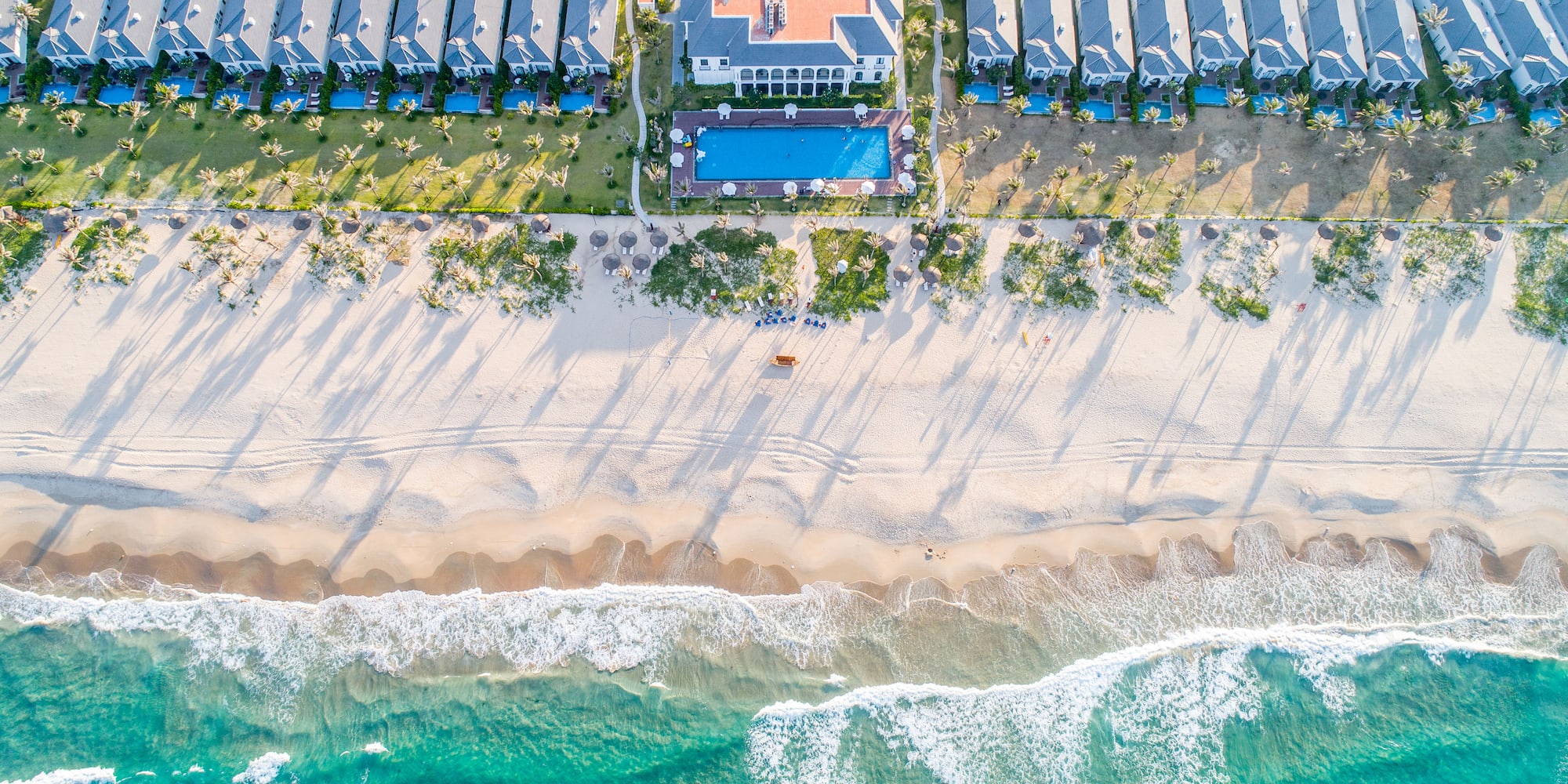a beach with houses and a pool