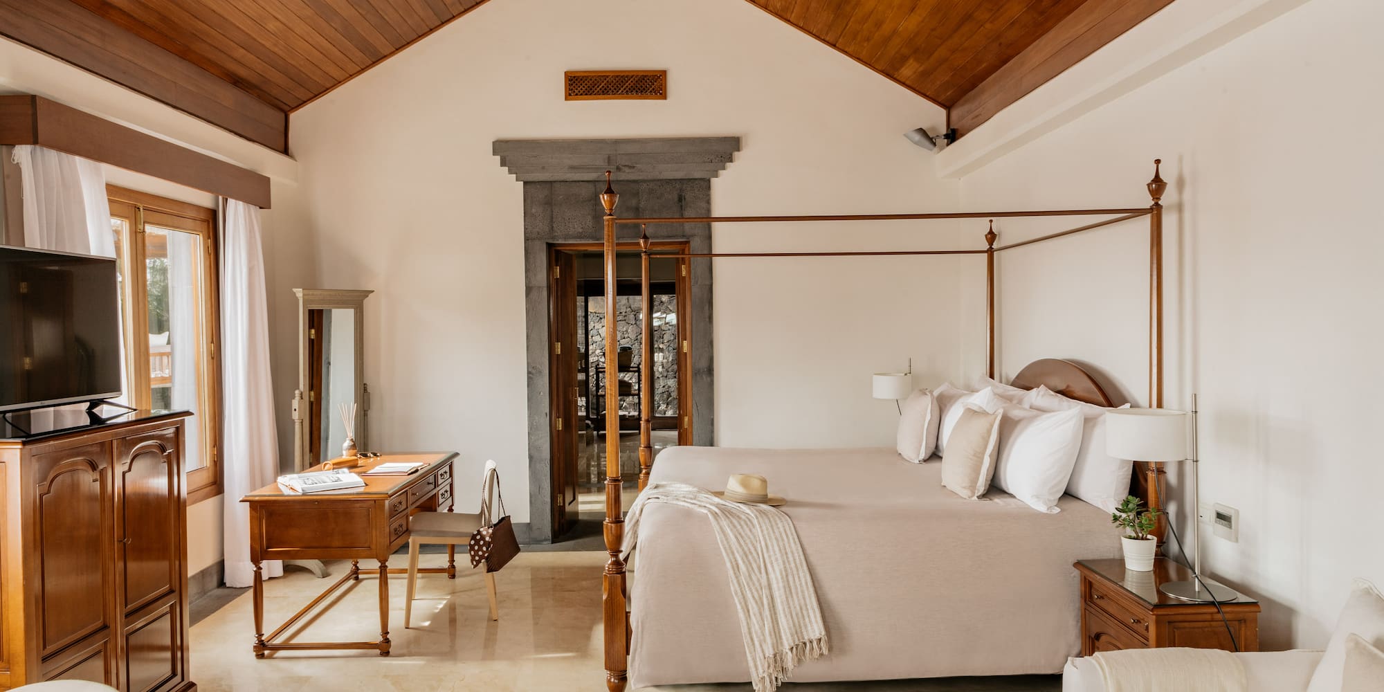 a bedroom with a four poster bed and a desk