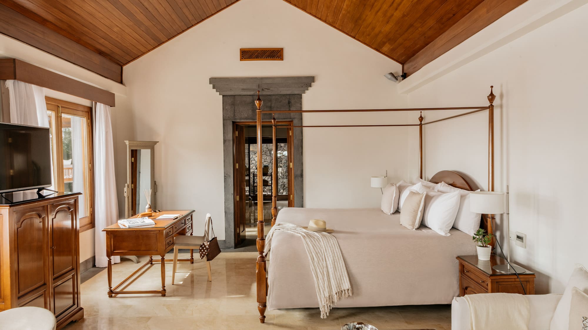 a bedroom with a four poster bed and a desk