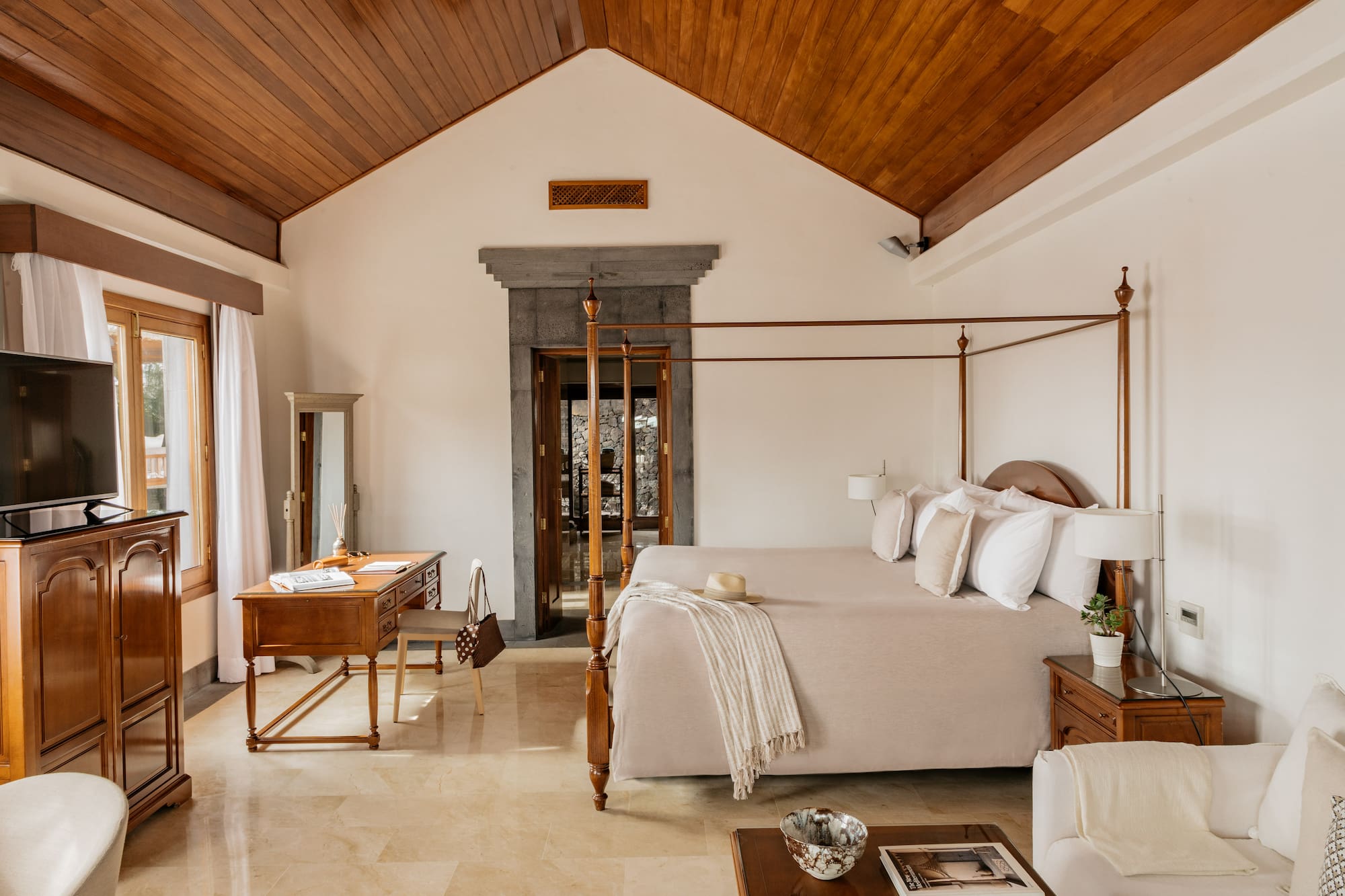 a bedroom with a four poster bed and a desk