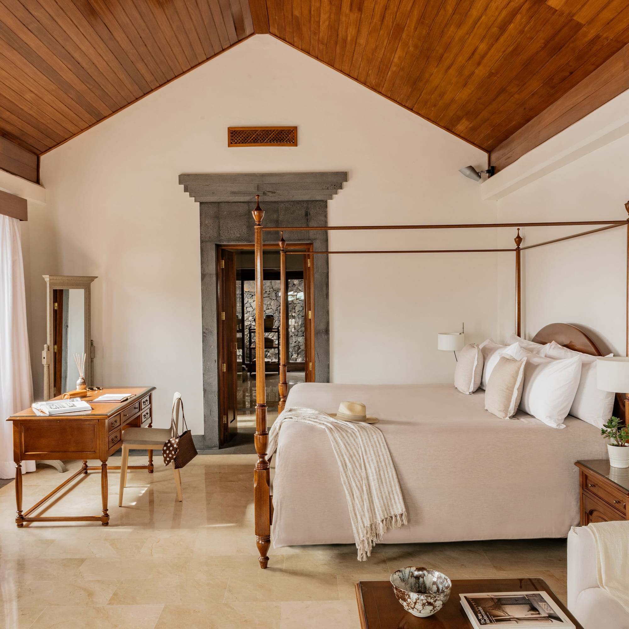 a bedroom with a four poster bed and a desk