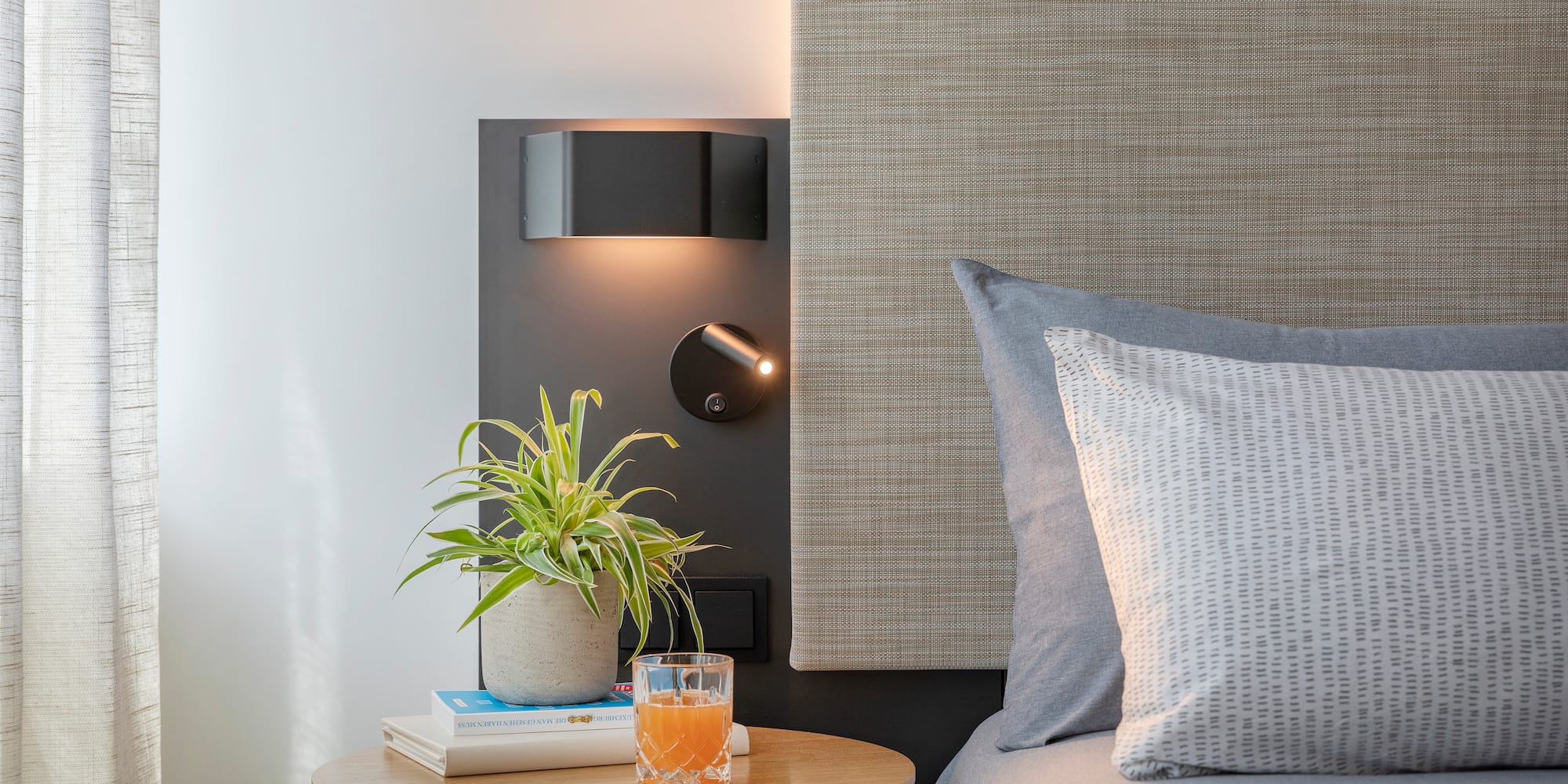 a table with a plant on it next to a bed