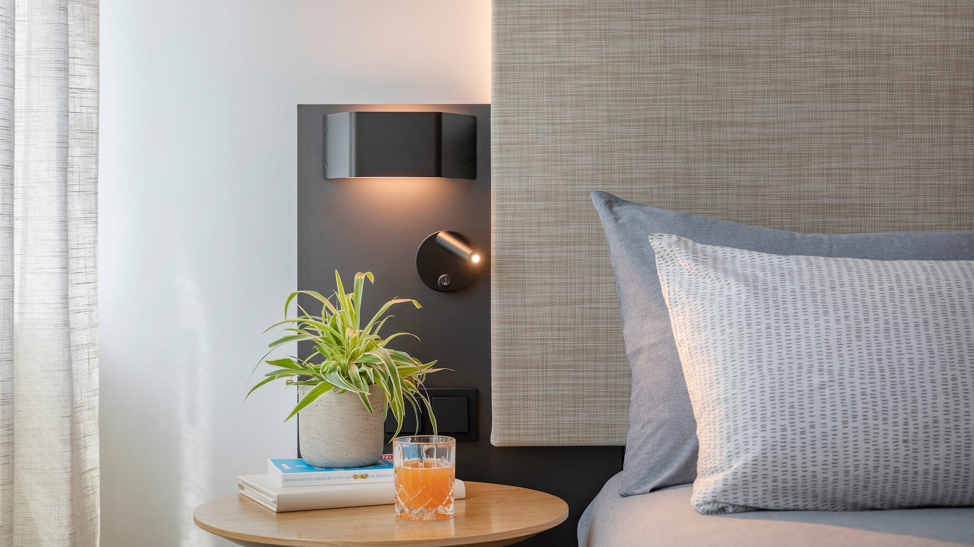 a table with a plant on it next to a bed