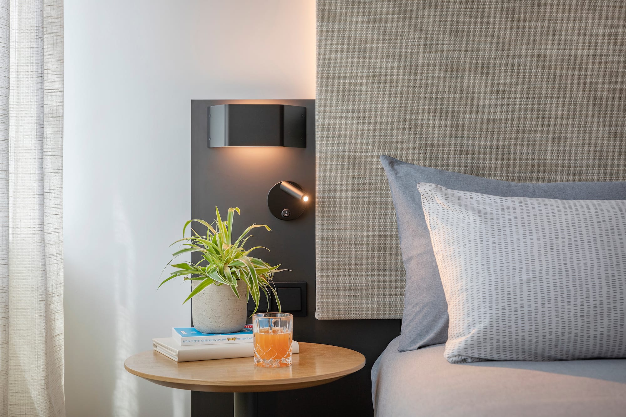 a table with a plant on it next to a bed