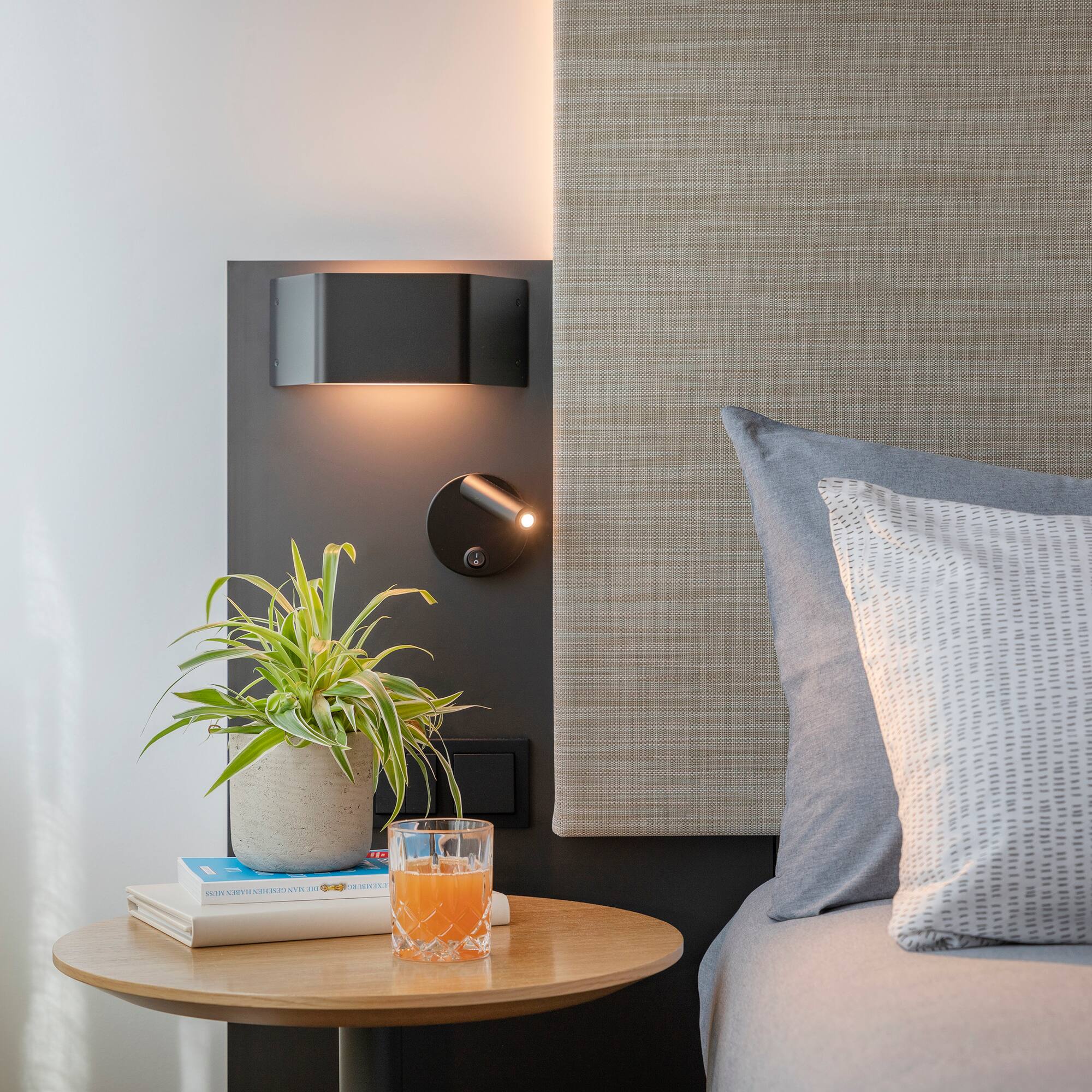 a table with a plant on it next to a bed